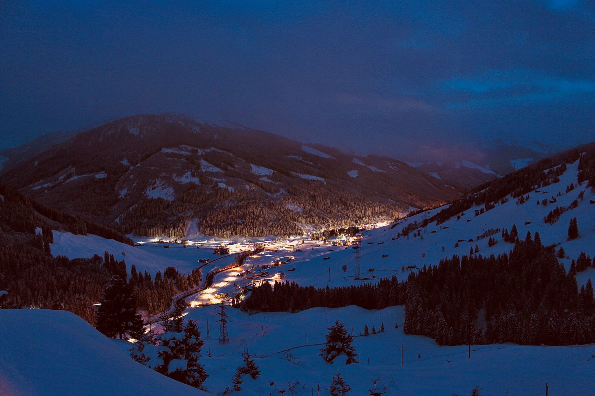 The village of St. Anton am Arlberg nestled in a snowy valley beneath steep ski slopes