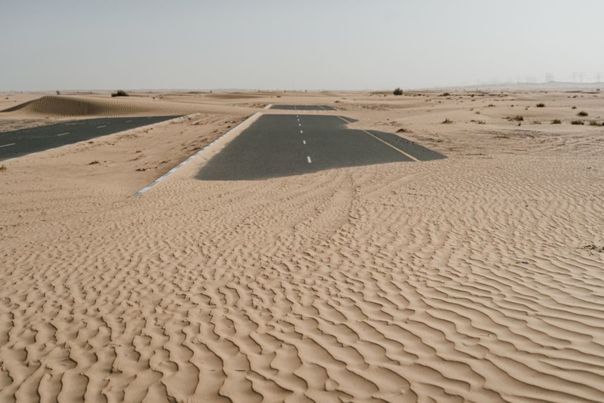 The empty grandstands and pit straight of the Bahrain International Circuit against a backdrop of open desert