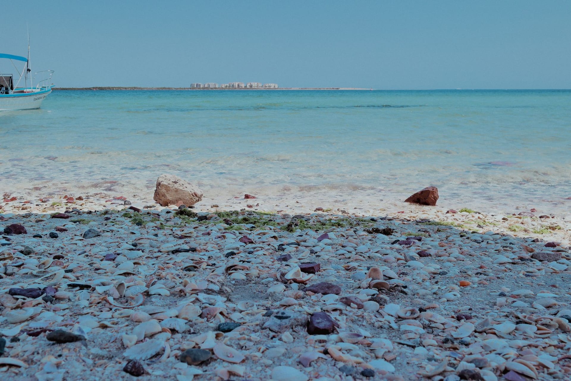 Hawar Islands mangroves and turquoise Gulf water from above, Qatar's low coastline faint on the horizon