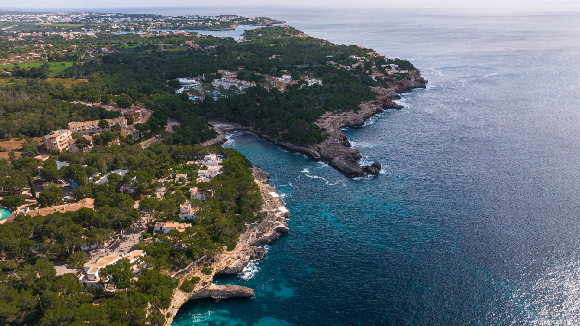 Honey-colored stone houses of Deià terraced into the limestone hillside above the Mediterranean