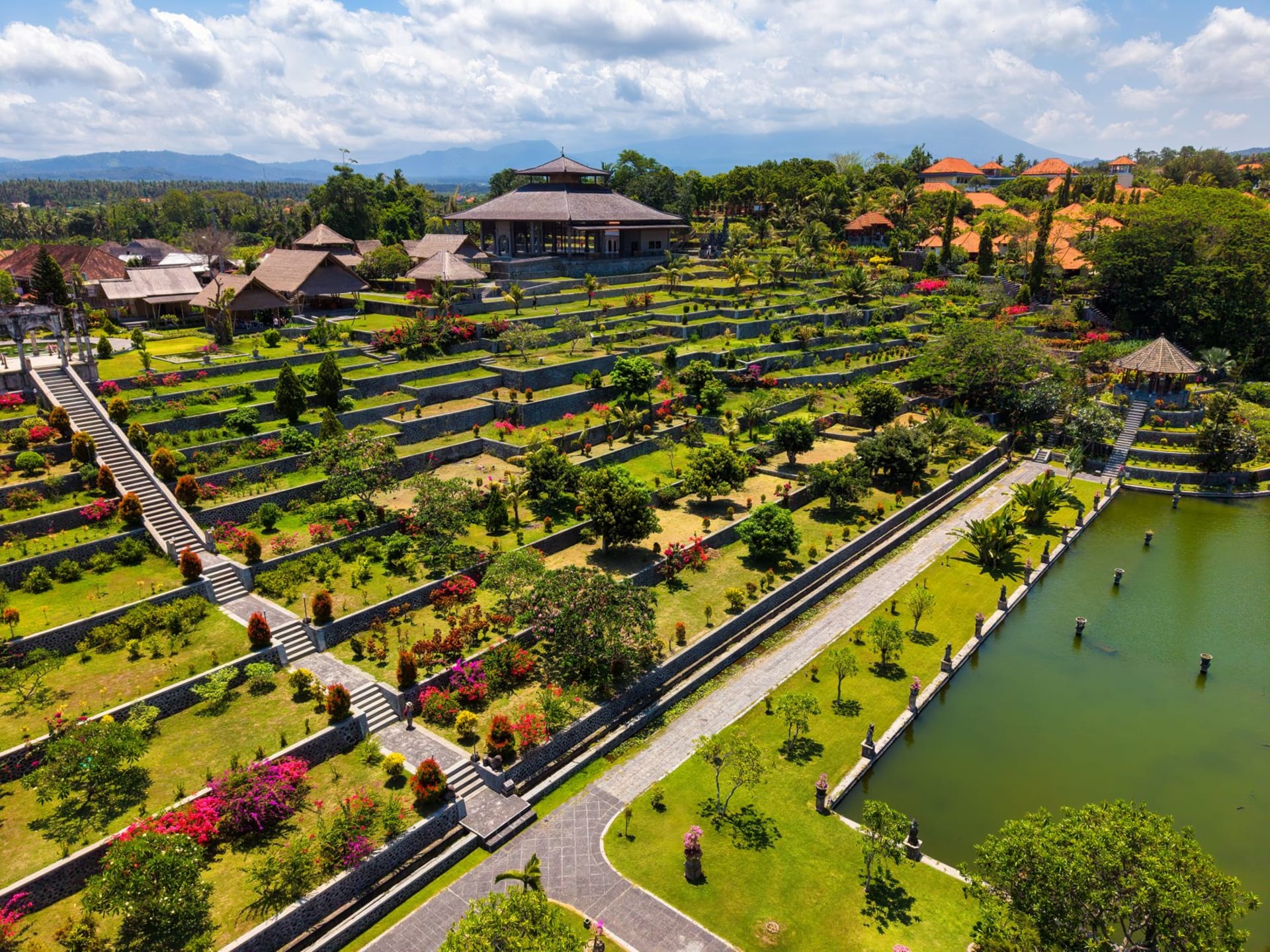 Tirta Gangga royal water palace fountain with stone carvings and koi-filled pools surrounded by lush tropical gardens