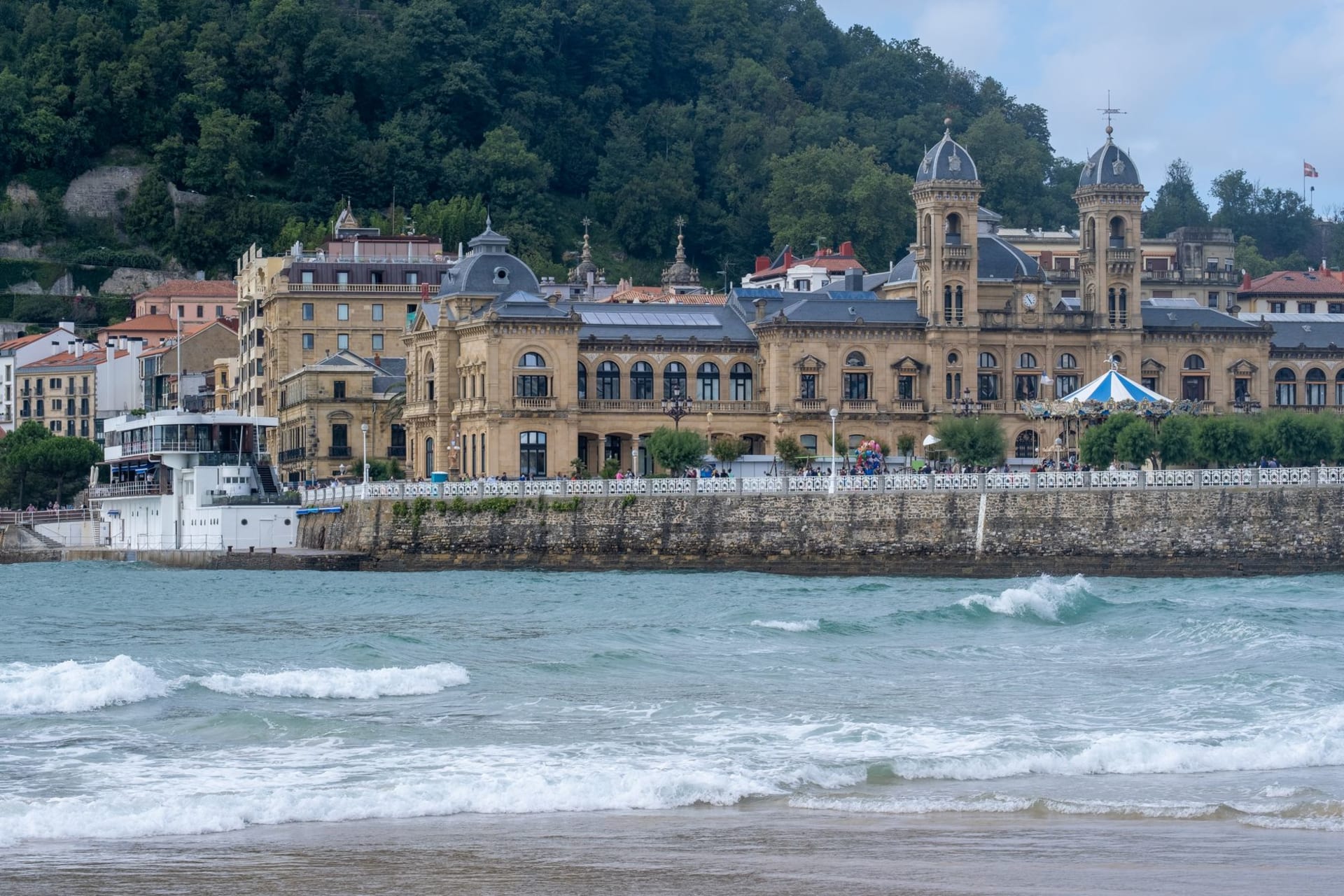 Grand Belle Époque architecture lining the seafront promenade of San Sebastián, with the Atlantic stretching out behind it under a pale sky