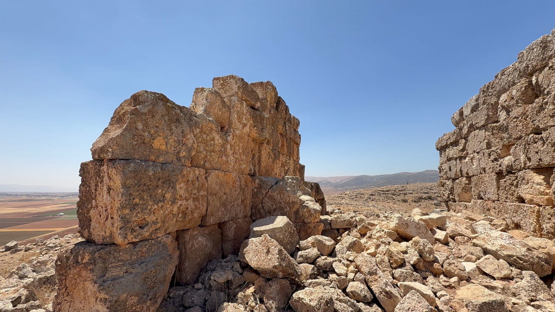 Ancient stone ruins of the Baalbek temple complex rising against a vast clear blue sky