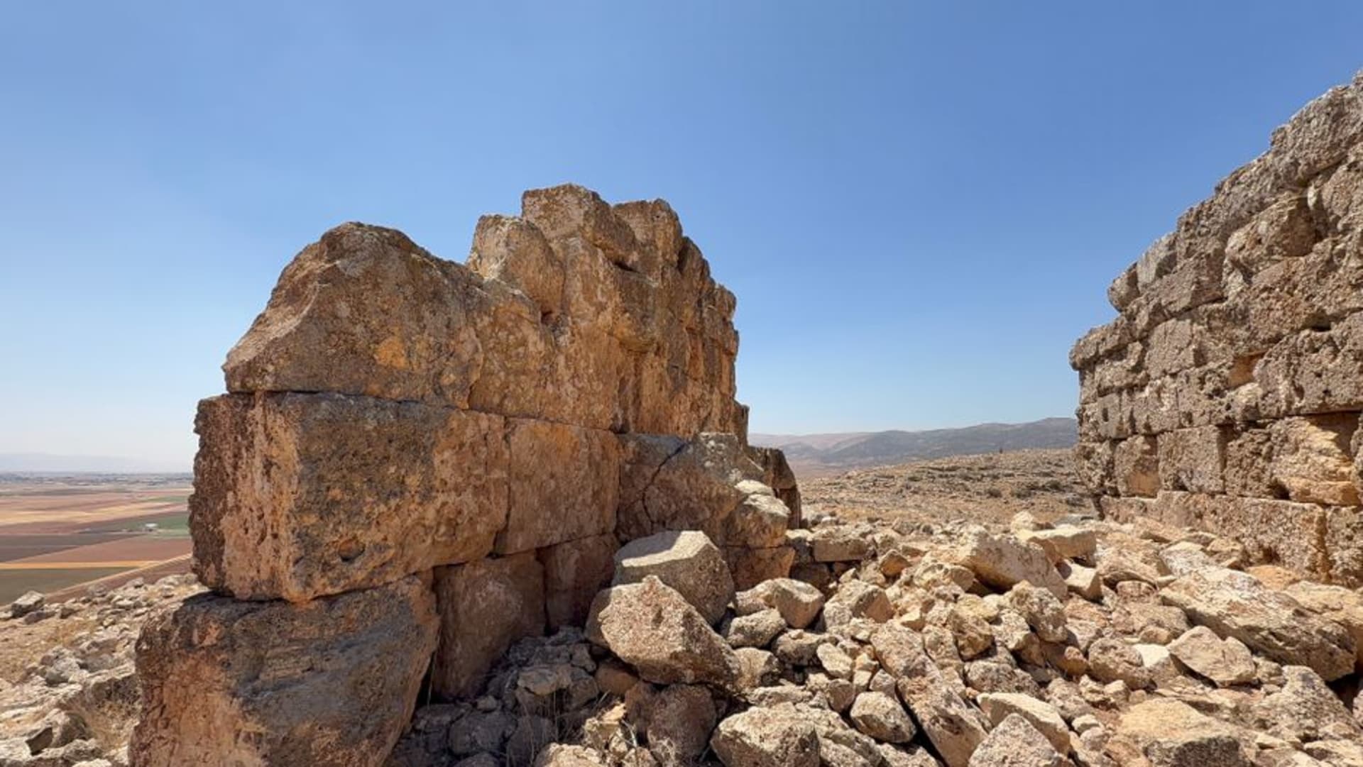 Los cimientos de adobe excavados del palacio de la Edad del Bronce en Tell Kamid el-Loz, con la llanura abierta del Bekaa extendiéndose detrás