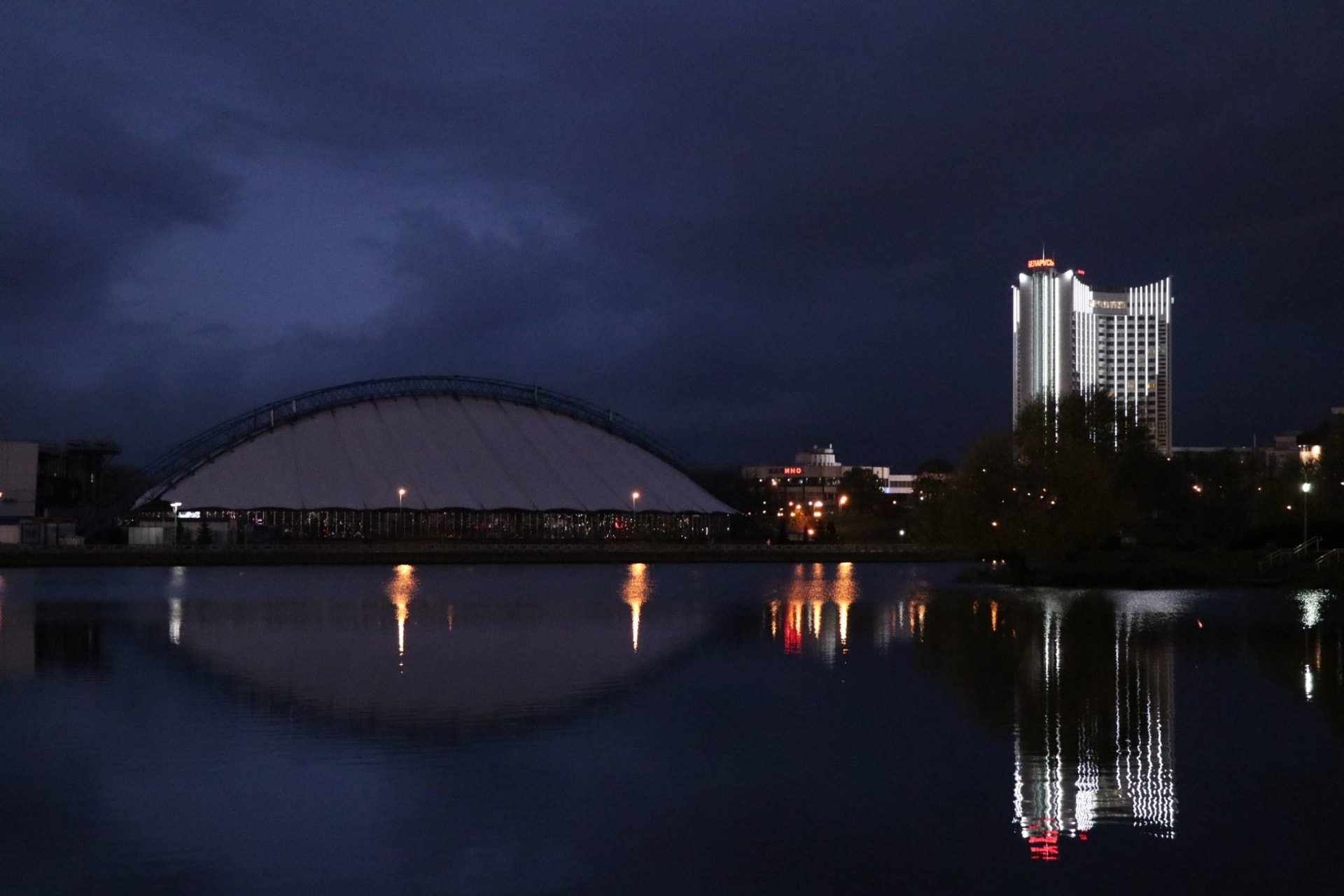 Illuminated Soviet-era buildings reflecting in the Svislach River at night in Minsk, Belarus