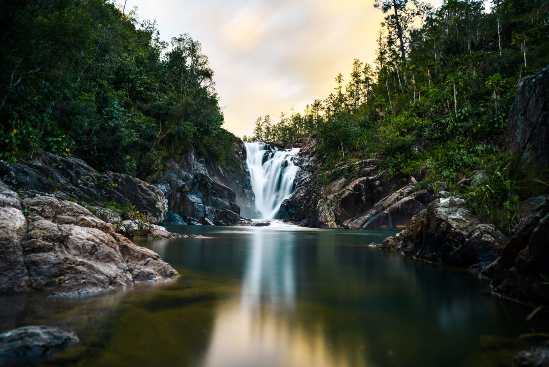 Hidden Valley Falls cascading over granite cliffs into a jungle pool in Mountain Pine Ridge Forest Reserve, Belize