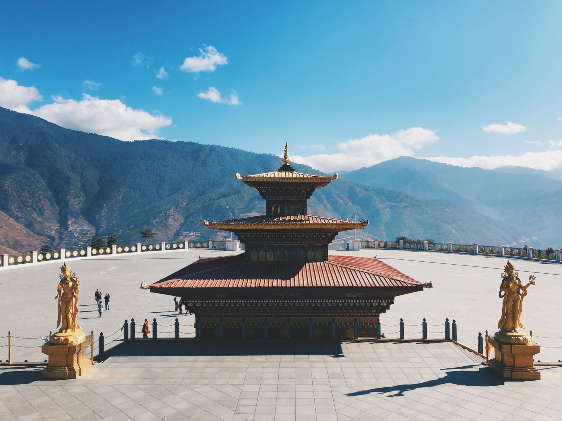 Tashichho Dzong gleaming white against forested hills above the Wang Chhu river in Thimphu