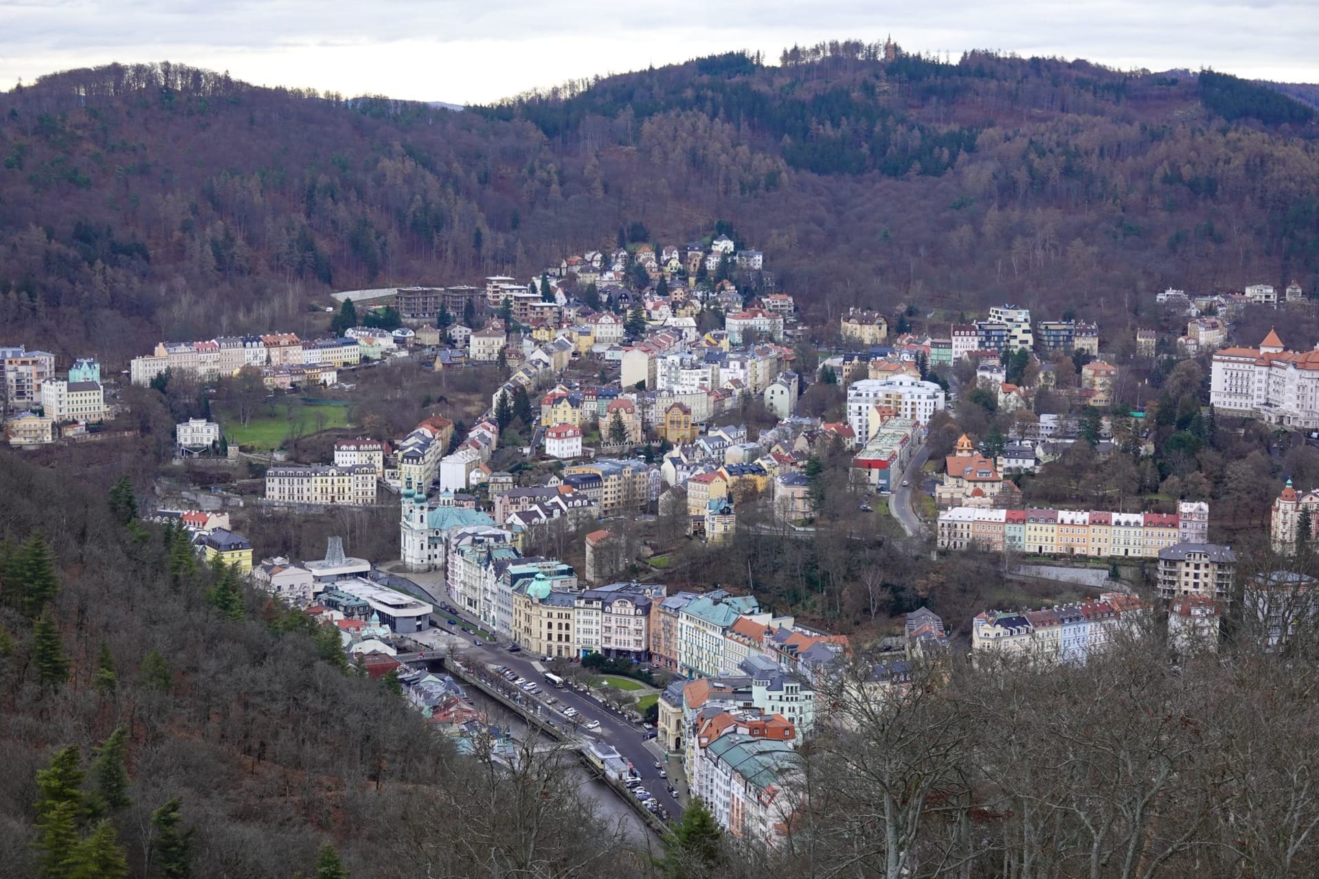 Les remparts médiévaux et la tour de Třeboň se reflétant dans un étang à poissons calme à l'heure dorée, entourés de roseaux et de saules