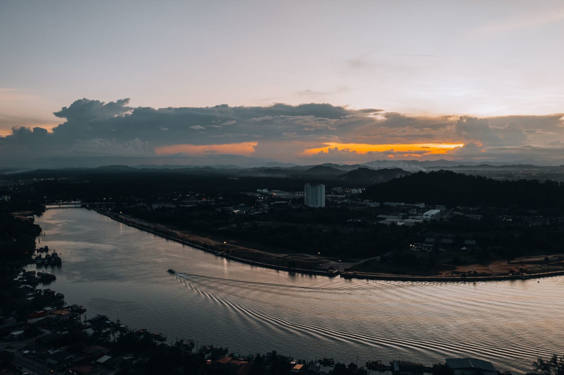 Kuching waterfront at sunset with Fort Margherita and colourful shophouses reflected in the Sarawak River