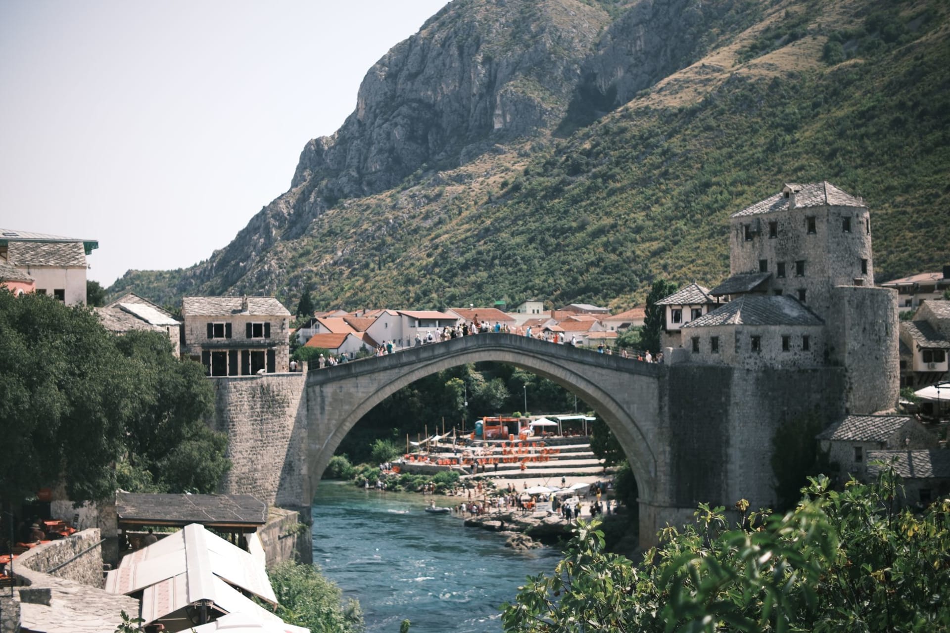 Scenic view of the Stari Most bridge in Mostar, Bosnia with surrounding hills, photo by Emirhan Emiroğlu