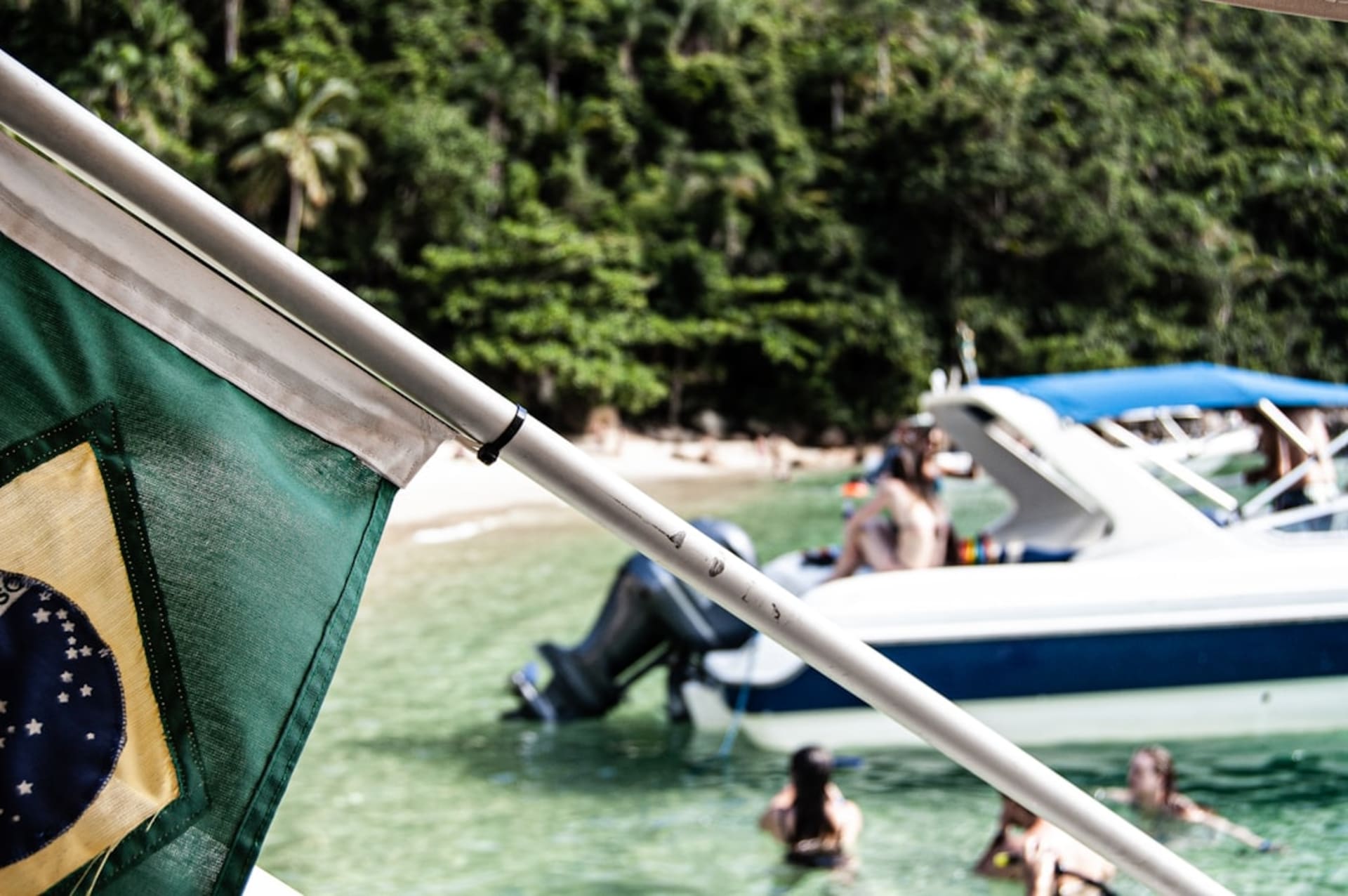 A hand-pulled wooden raft crossing the Tatajuba river channel with a wall of white dunes rising on the far bank