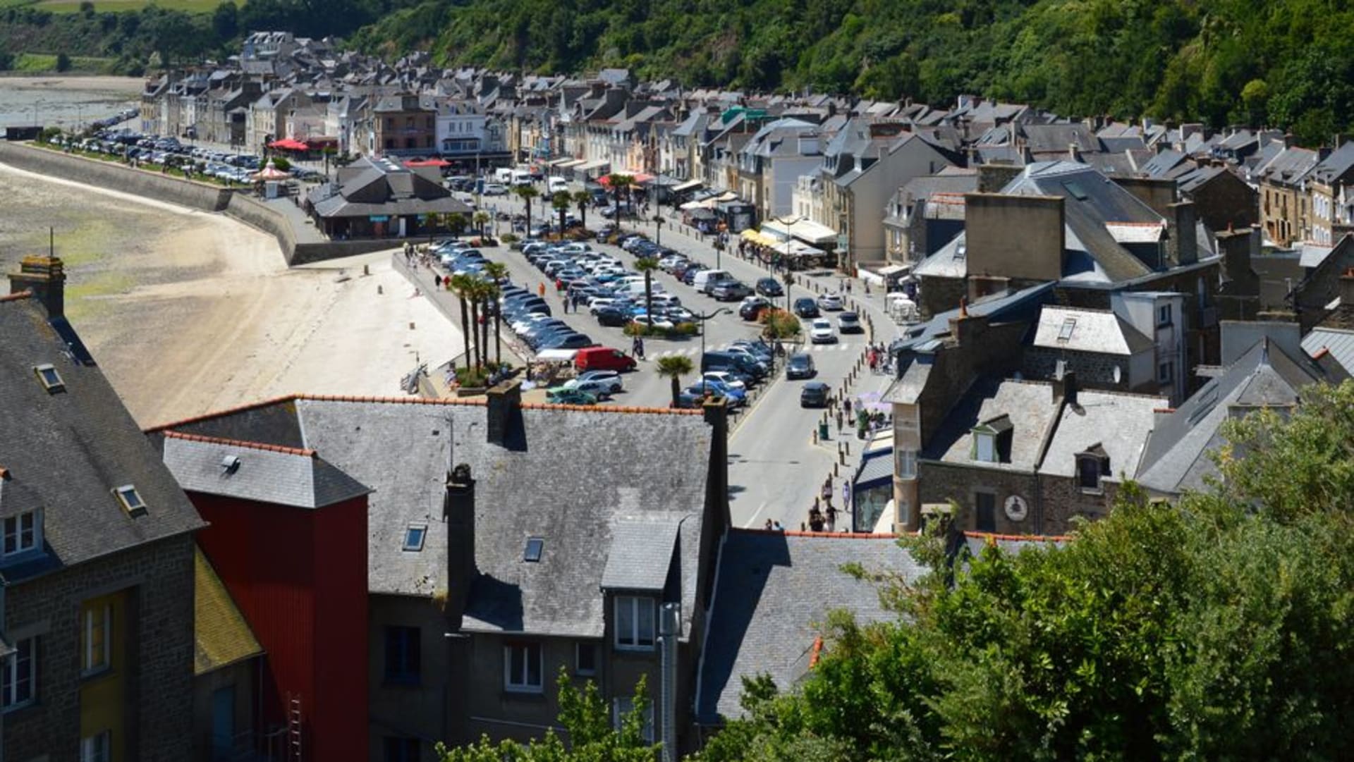 Granite houses and the steeple of Église Saint-Ronan lining the sloped main square of Locronan