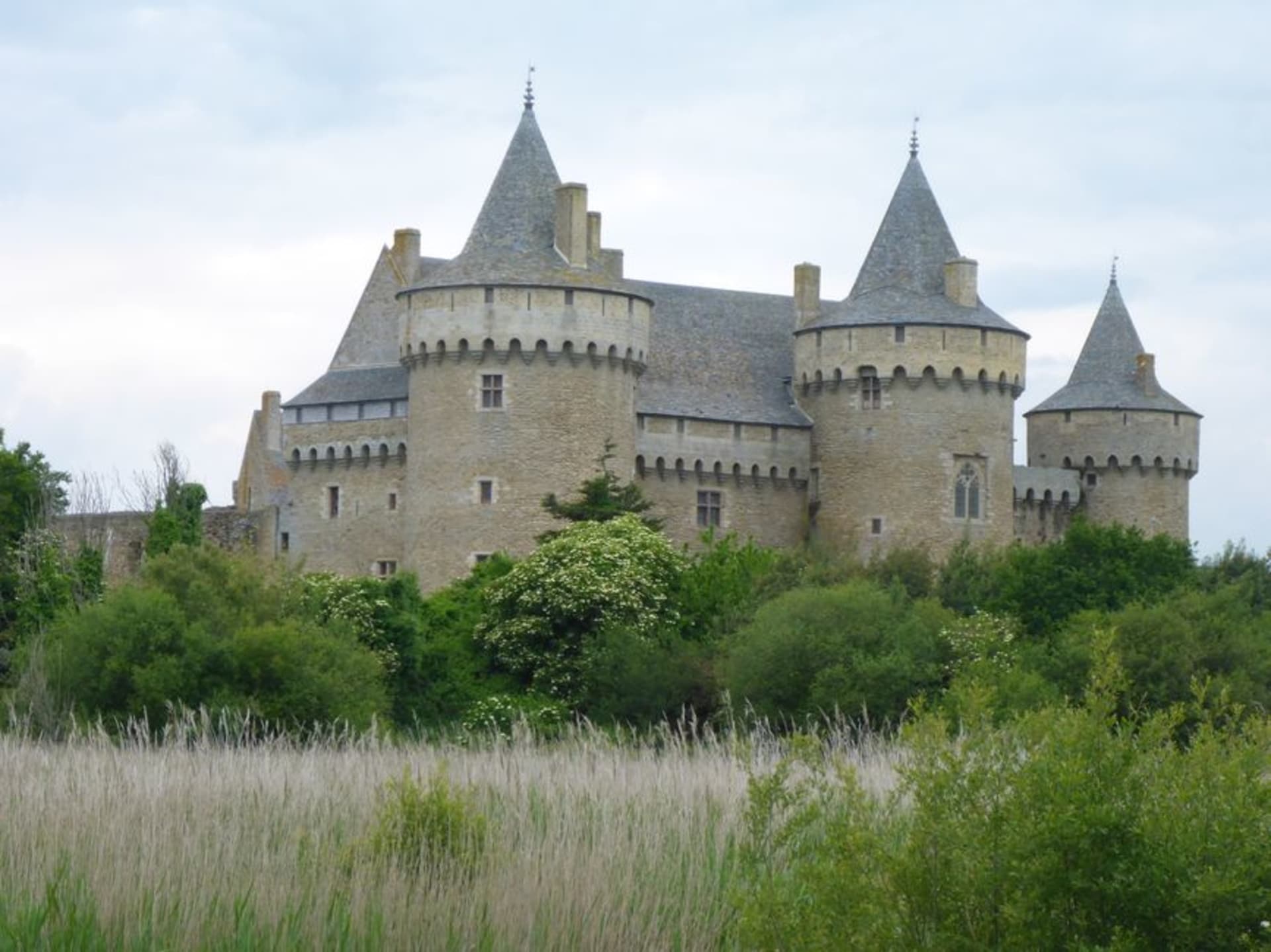 Château de Suscinio's fortified towers reflected in still water at dusk on the Presqu'île de Rhuys