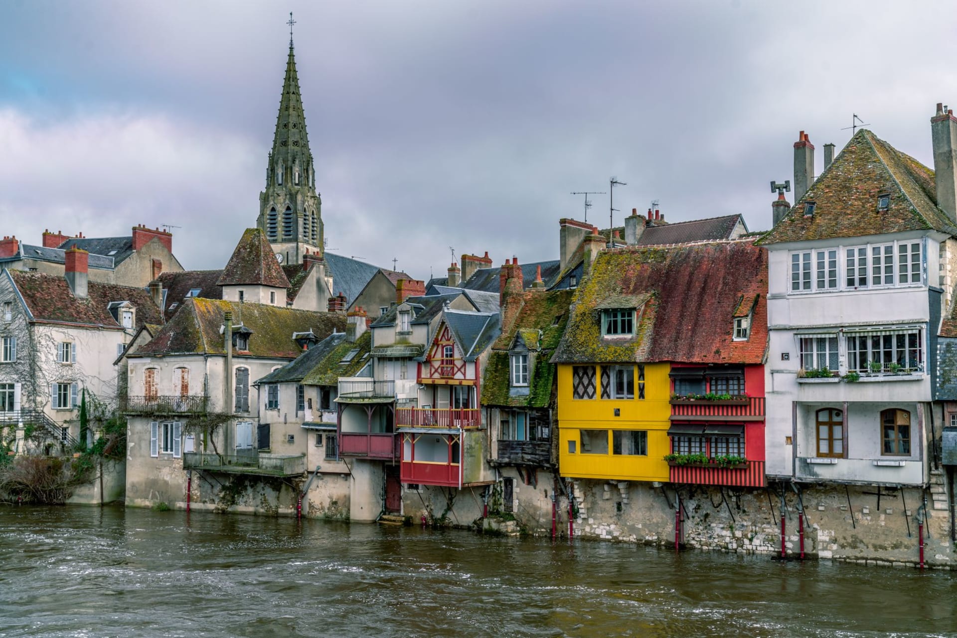 Auxerre's Gothic cathedral and medieval riverside quarter reflected in the still waters of the Yonne on a clear morning