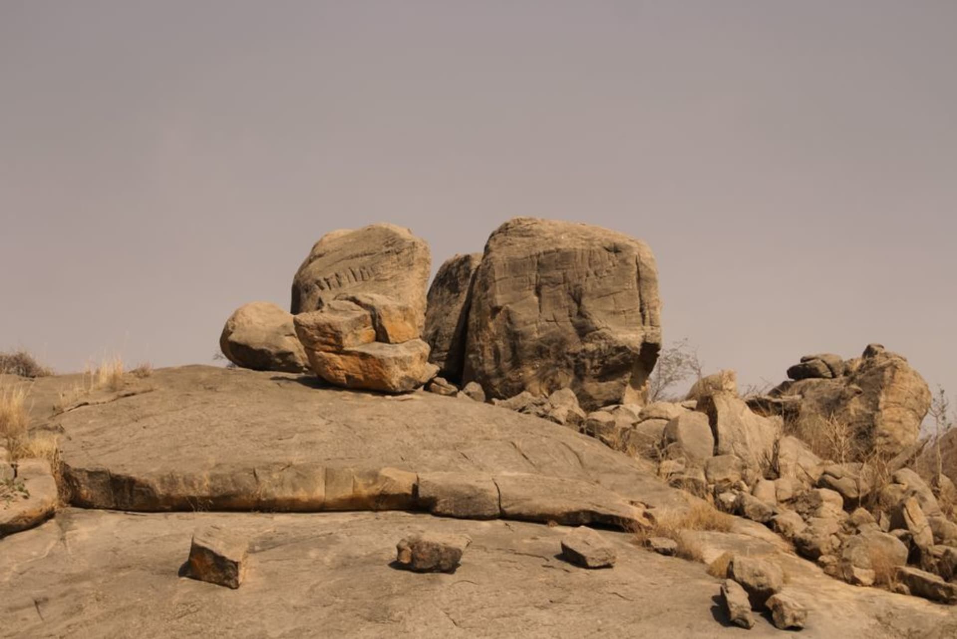 Granite outcrops rising above the savanna plains of Deux Balés National Park at dusk