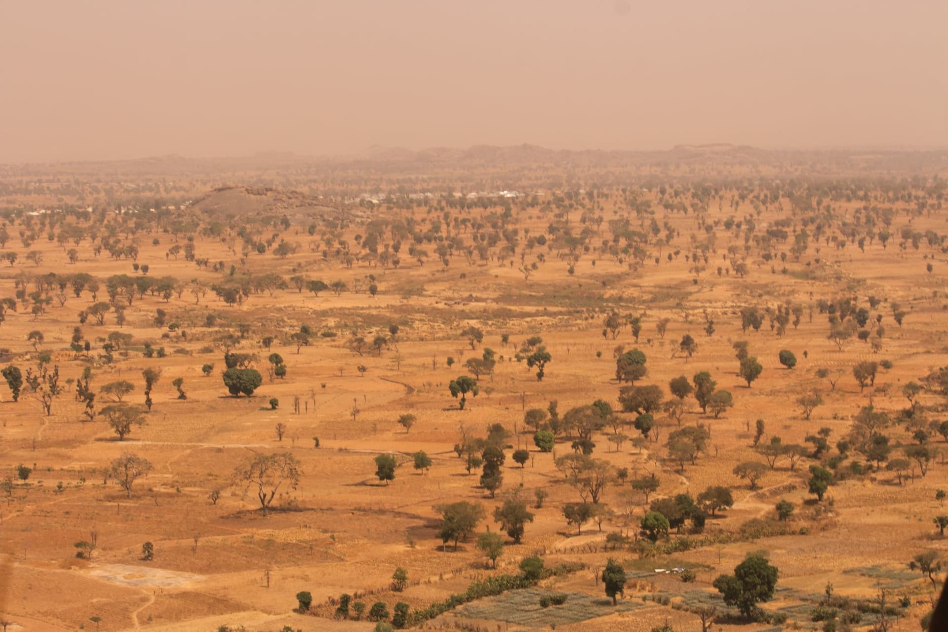 Las cataratas de Karfiguéla desplomándose sobre roca oscura hacia una poza verde y cristalina rodeada de vegetación tropical en el suroeste de Burkina Faso