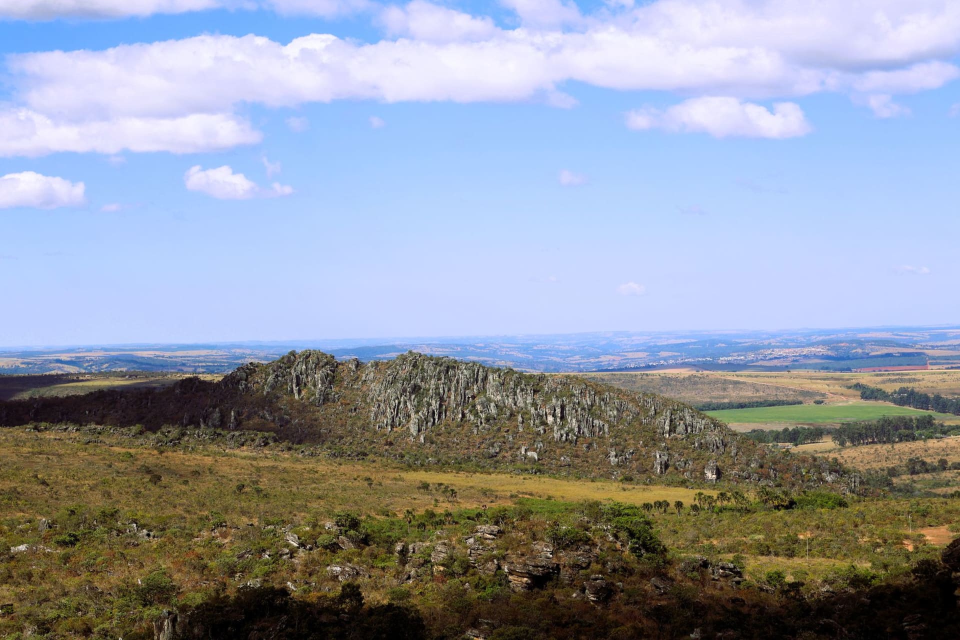 Stone ruins of Canudos emerging from the shallow edges of Cocorobó reservoir at low water, framed by dry caatinga scrub