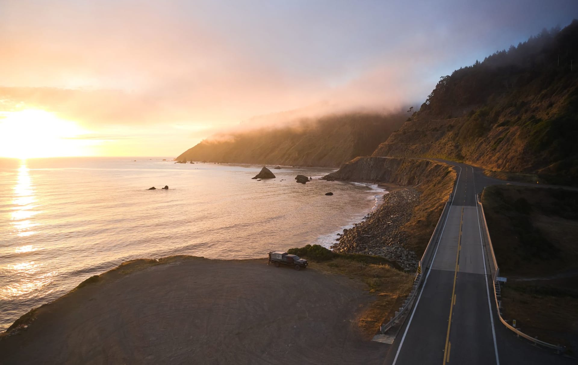 Black sand beach of the Lost Coast stretching north beneath the King Range, surf crashing against shore, not another person visible