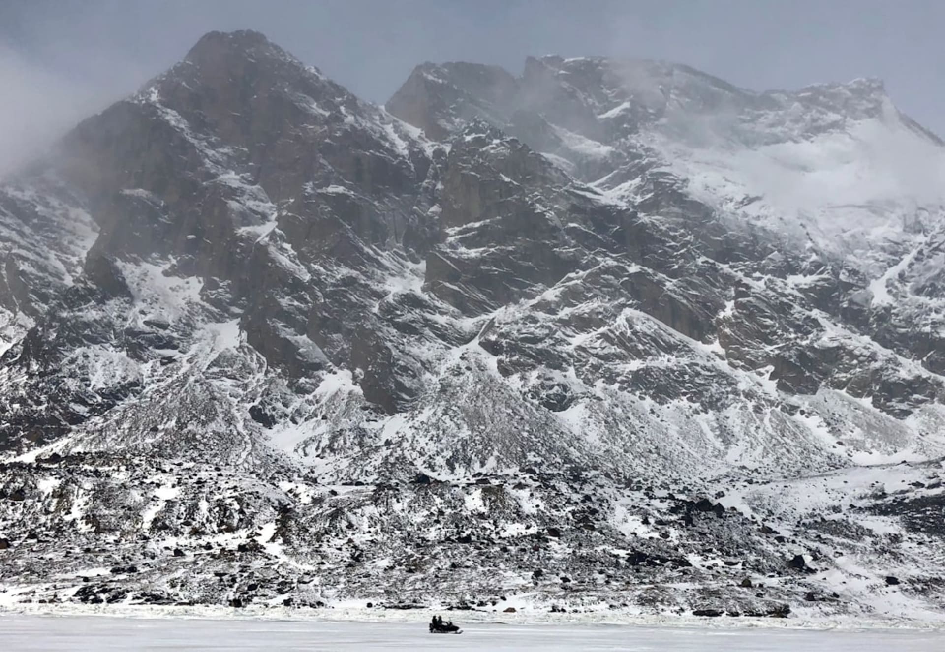 Sharp granite peaks and a glacier flowing into a fjord in Auyuittuq National Park on Baffin Island