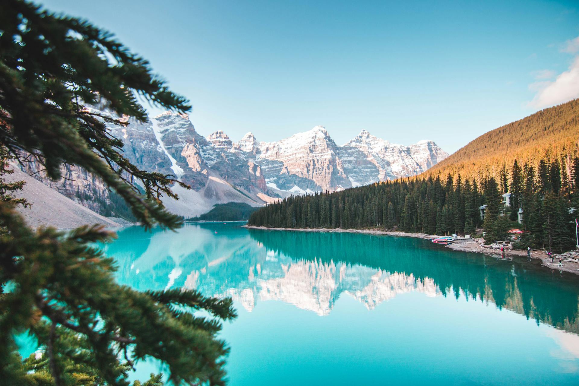 Turquoise glacial lake surrounded by snow-capped Rocky Mountain peaks