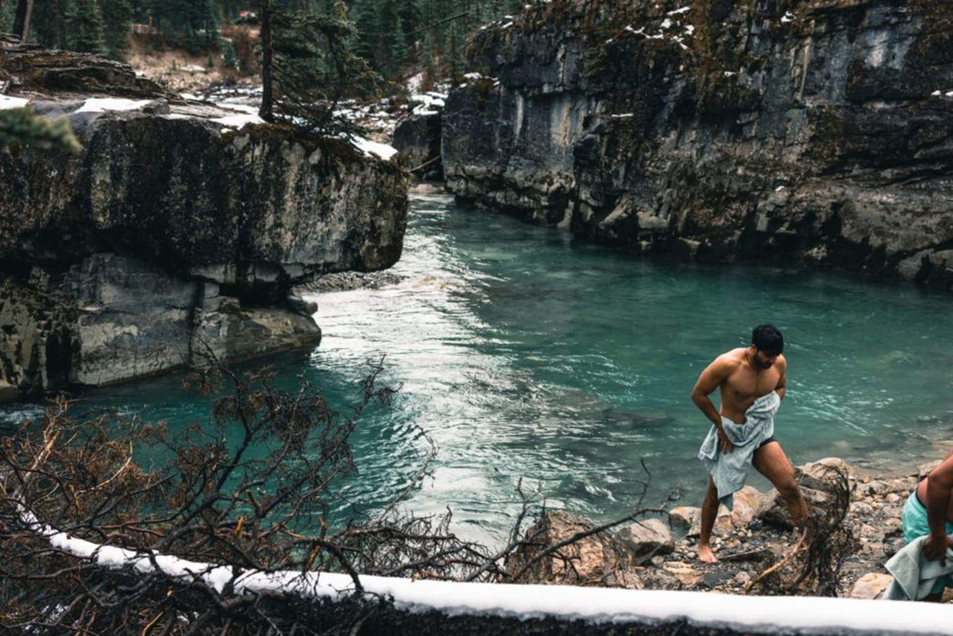 Marble Canyon's narrow limestone gorge with a footbridge crossing high above rushing turquoise meltwater