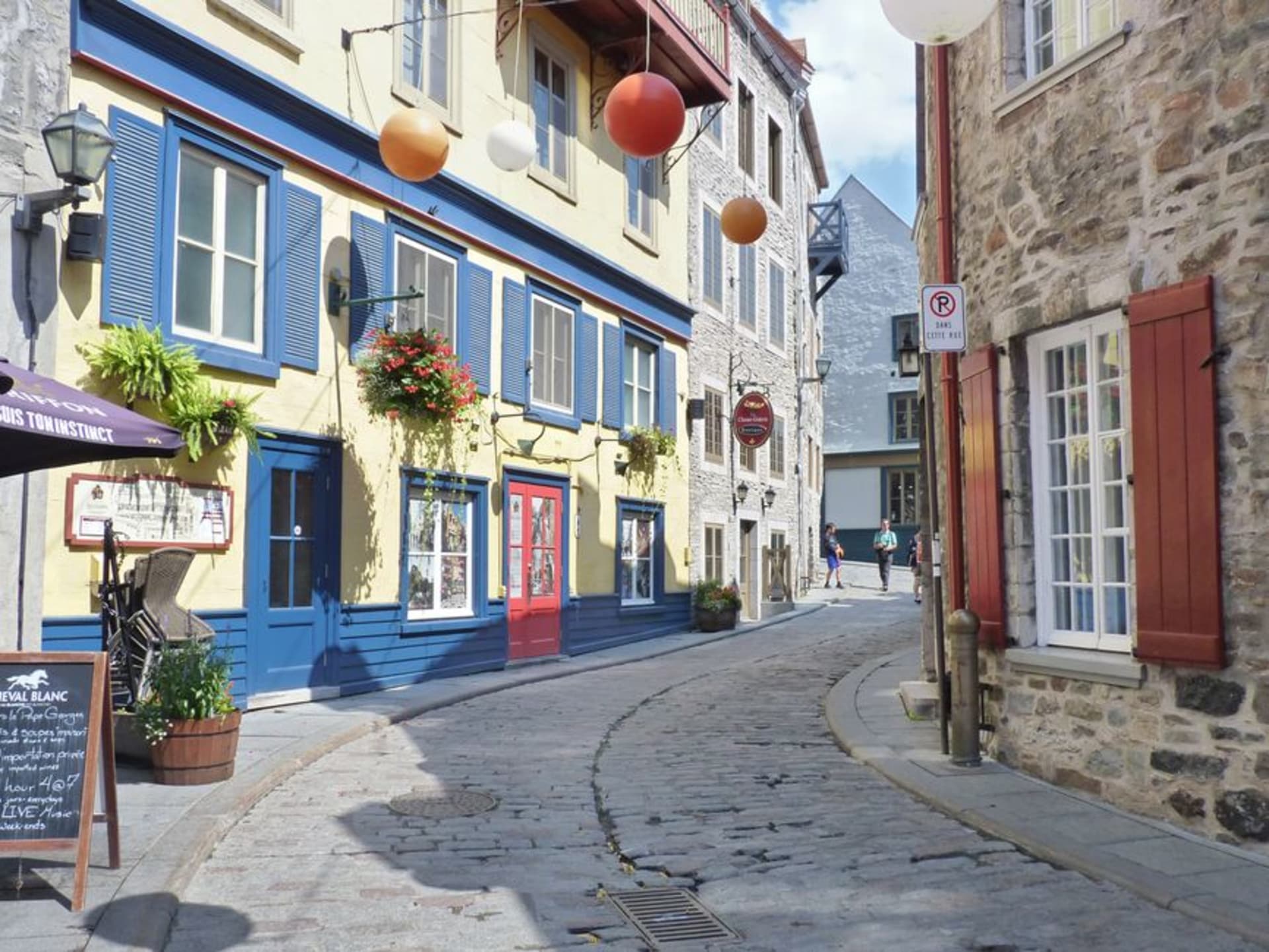 Historic stone buildings along a cobblestone street in old Trois-Rivières