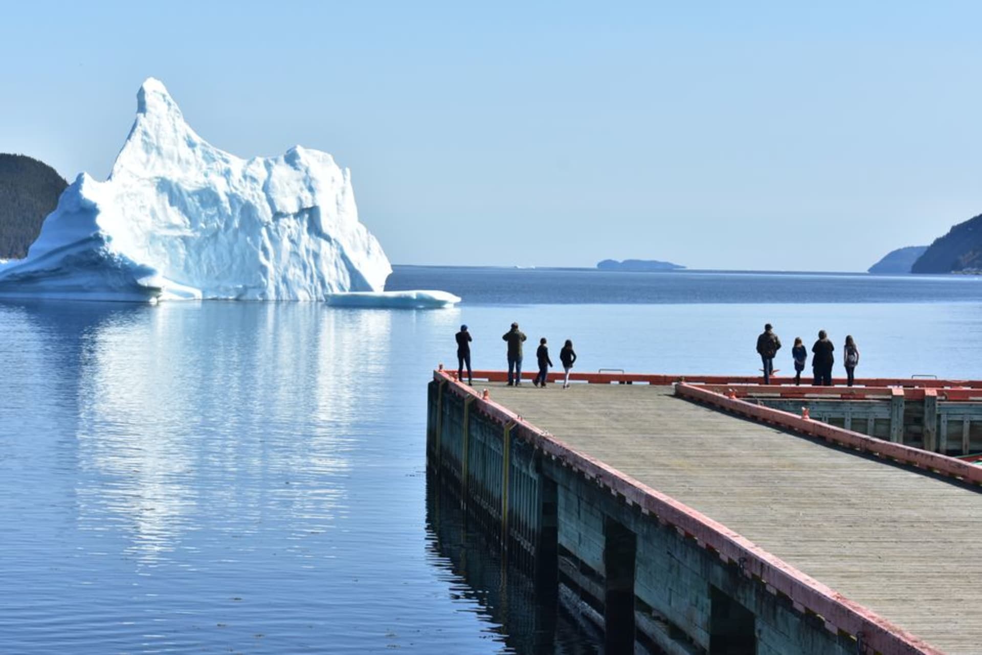 A massive white iceberg floating just offshore near the town of Twillingate