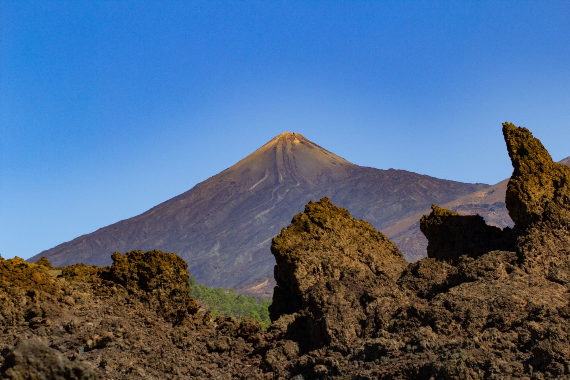 Mount Teide rising above a rugged volcanic terrain under a clear blue sky, Tenerife, Canary Islands