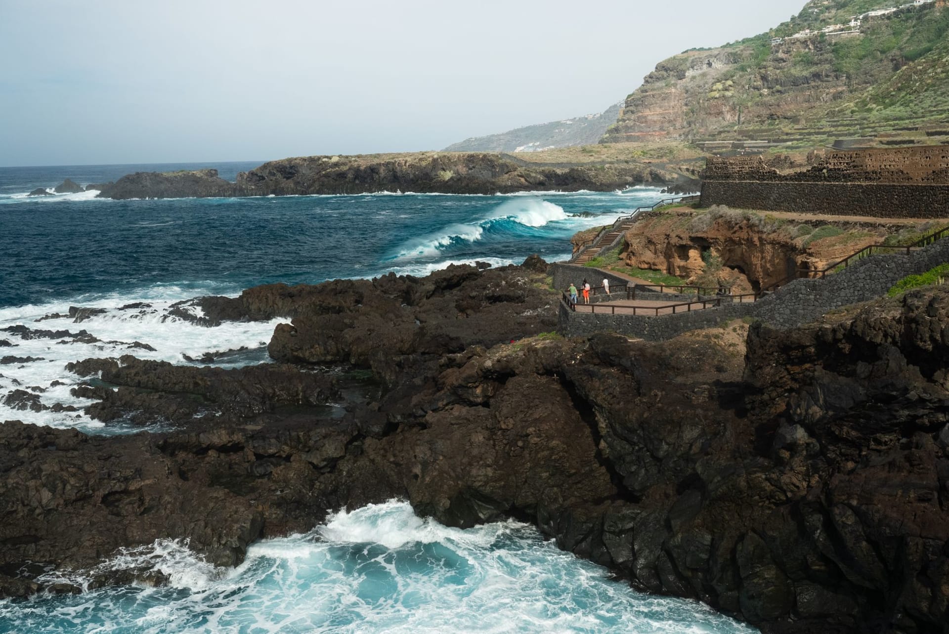 The dramatic volcanic coastline of El Hierro with crystal-clear turquoise natural pools carved into black lava rock, Canary Islands