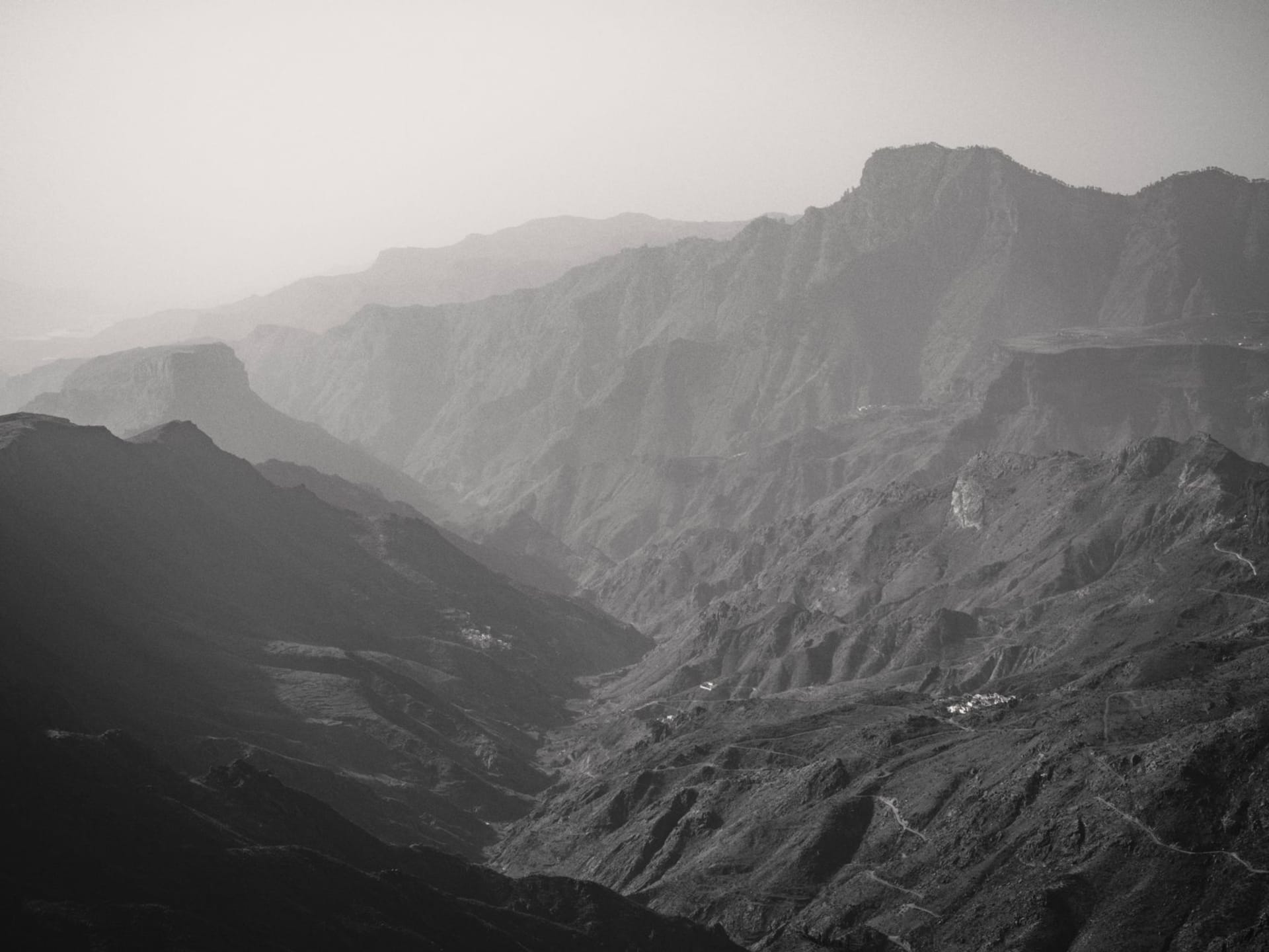Le village blanc de Tejeda perché sur le bord de la caldeira entouré de fleurs d'amandier avec des pics montagneux dramatiques derrière, Gran Canaria