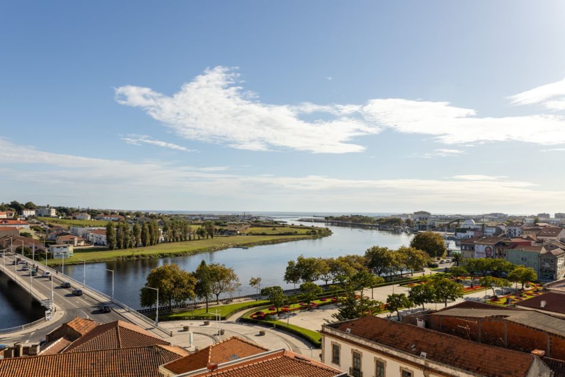 Longue plage déserte sur l'île de Maio avec des bâtiments coloniaux bas visibles près du port