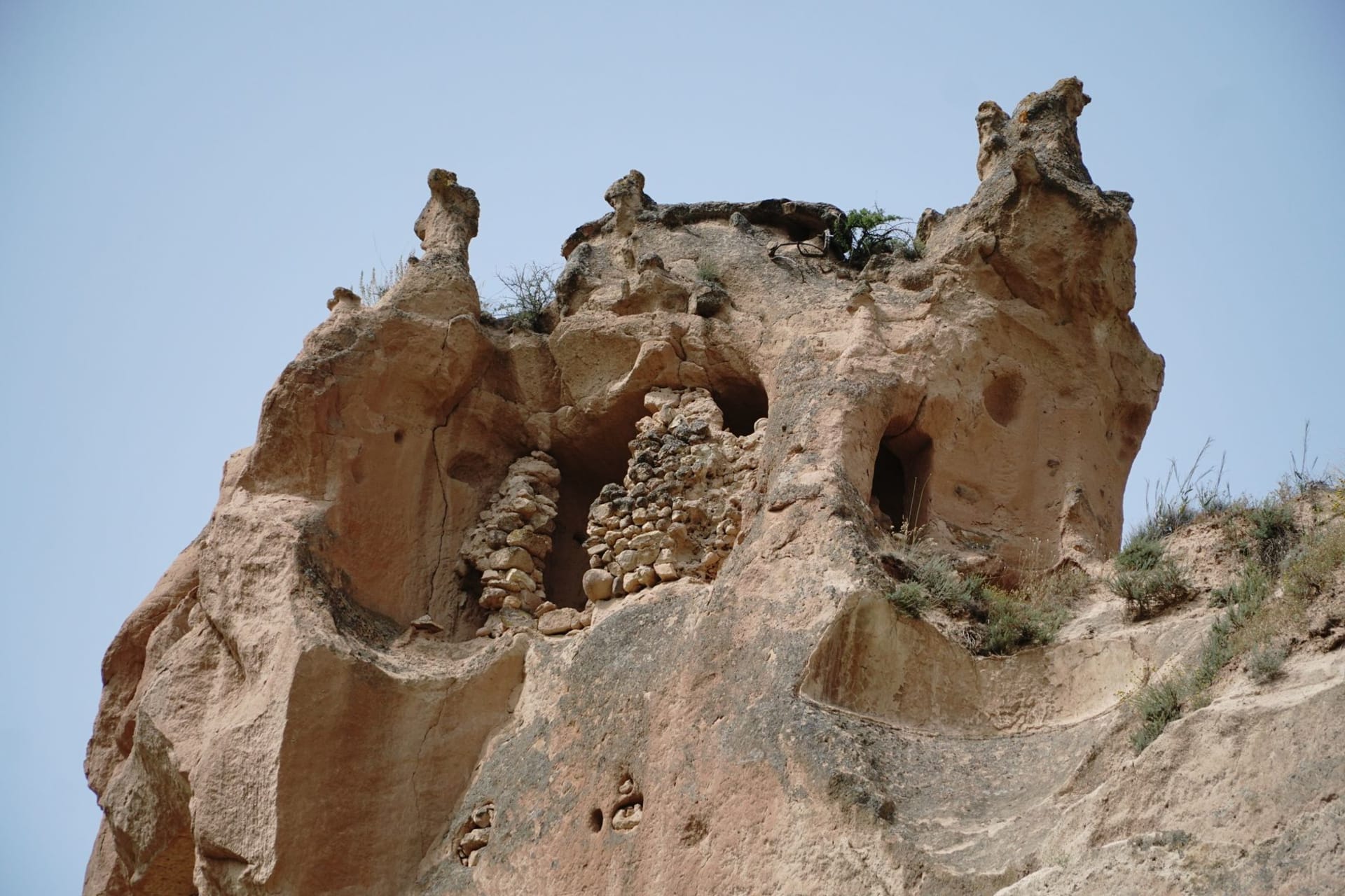 The abandoned multi-storey cave dwellings of Zelve carved into soft volcanic cones, doorways and windows cut into every surface of the cliff