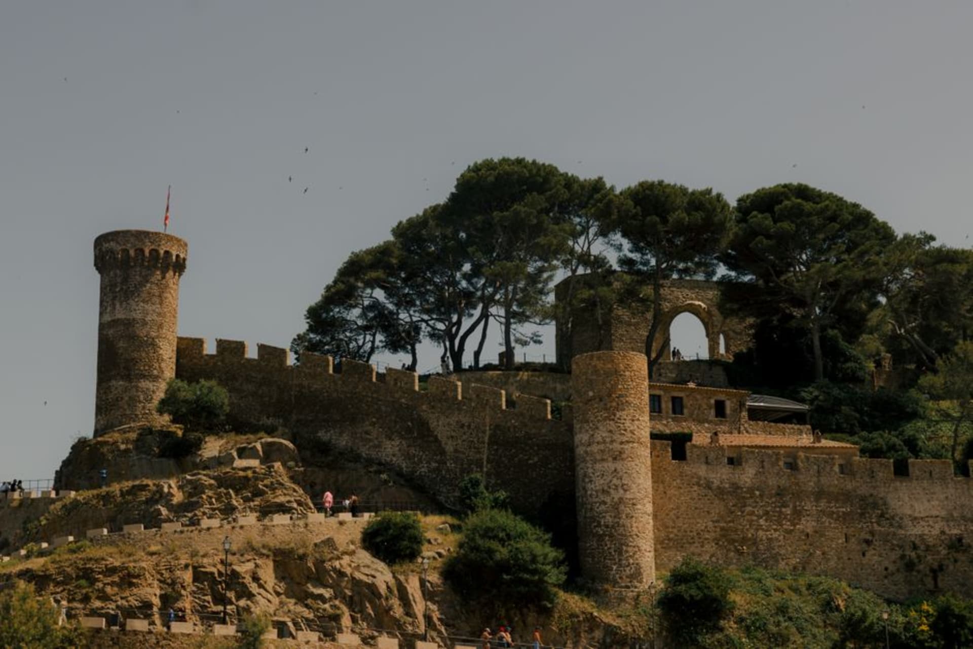The medieval walls and towers of Tossa de Mar's Vila Vella overlooking the beach at sunset