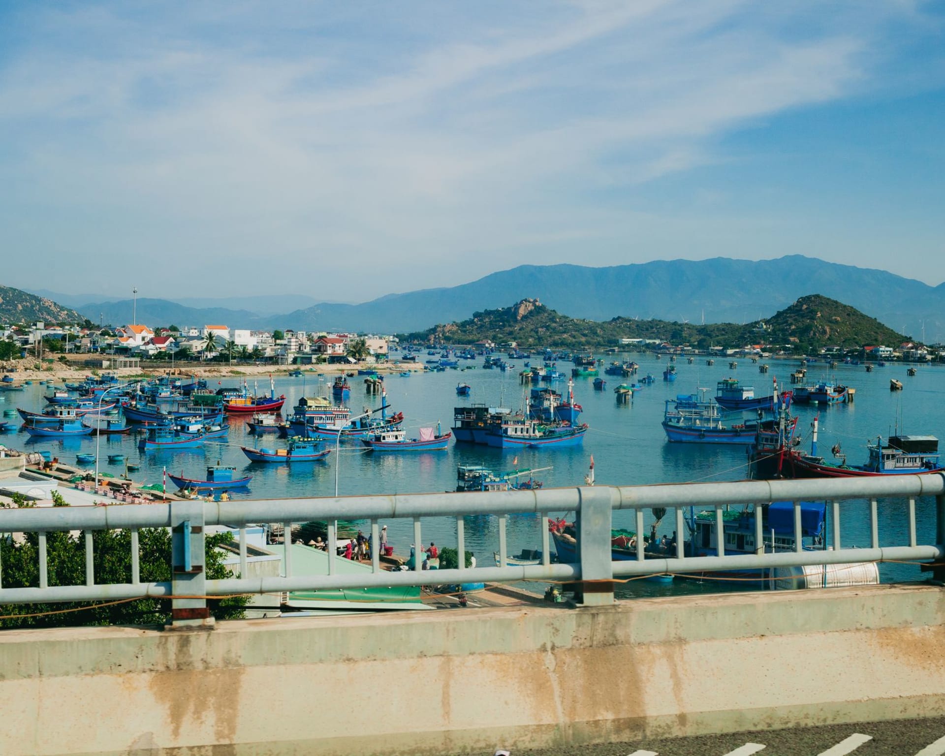Clear turquoise water over coral reef off Cù Lao Chàm island with wooden fishing boats anchored in the blue bay