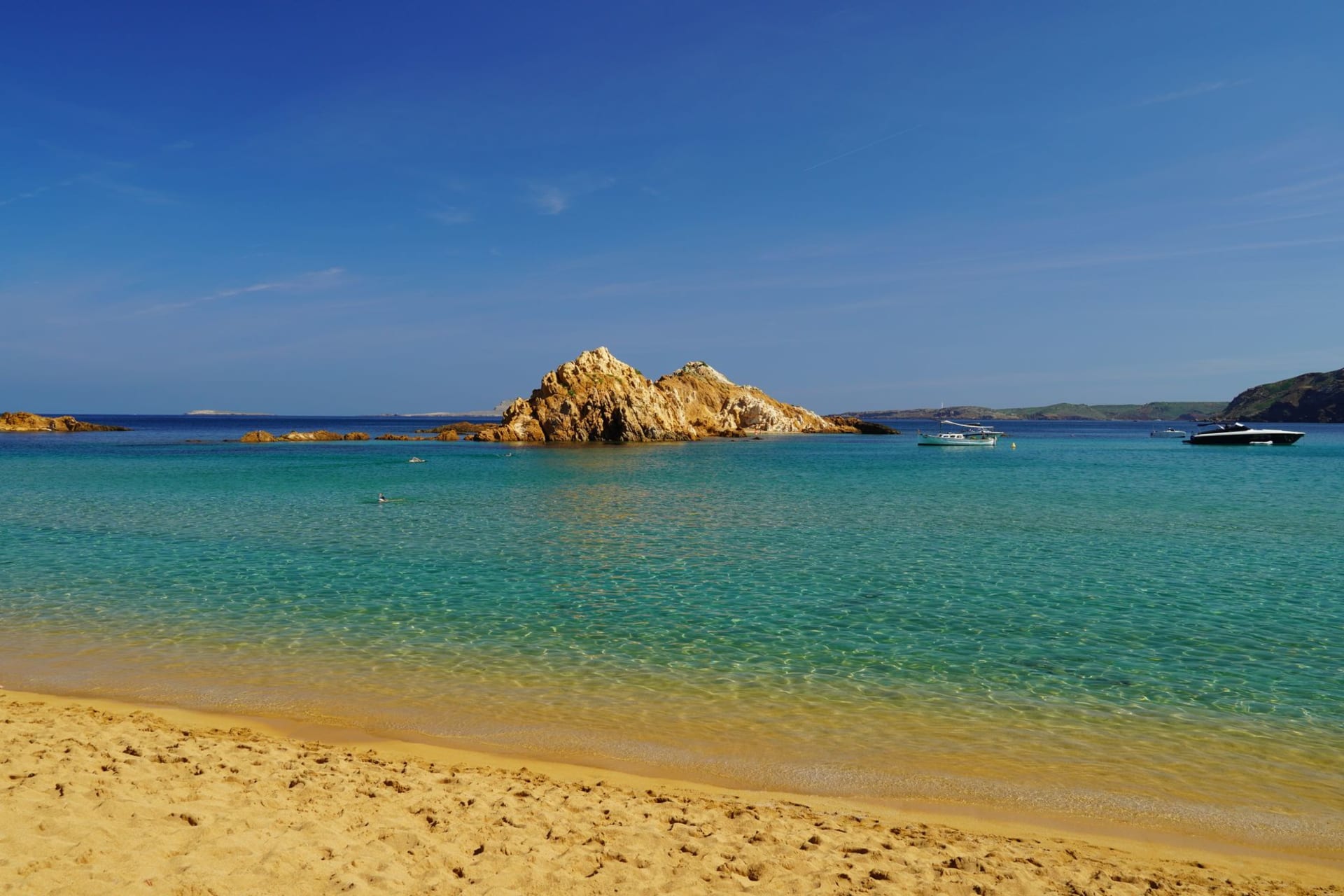 St. Brelade's Bay from the headland showing the curved sandy beach with turquoise water and the Norman chapel