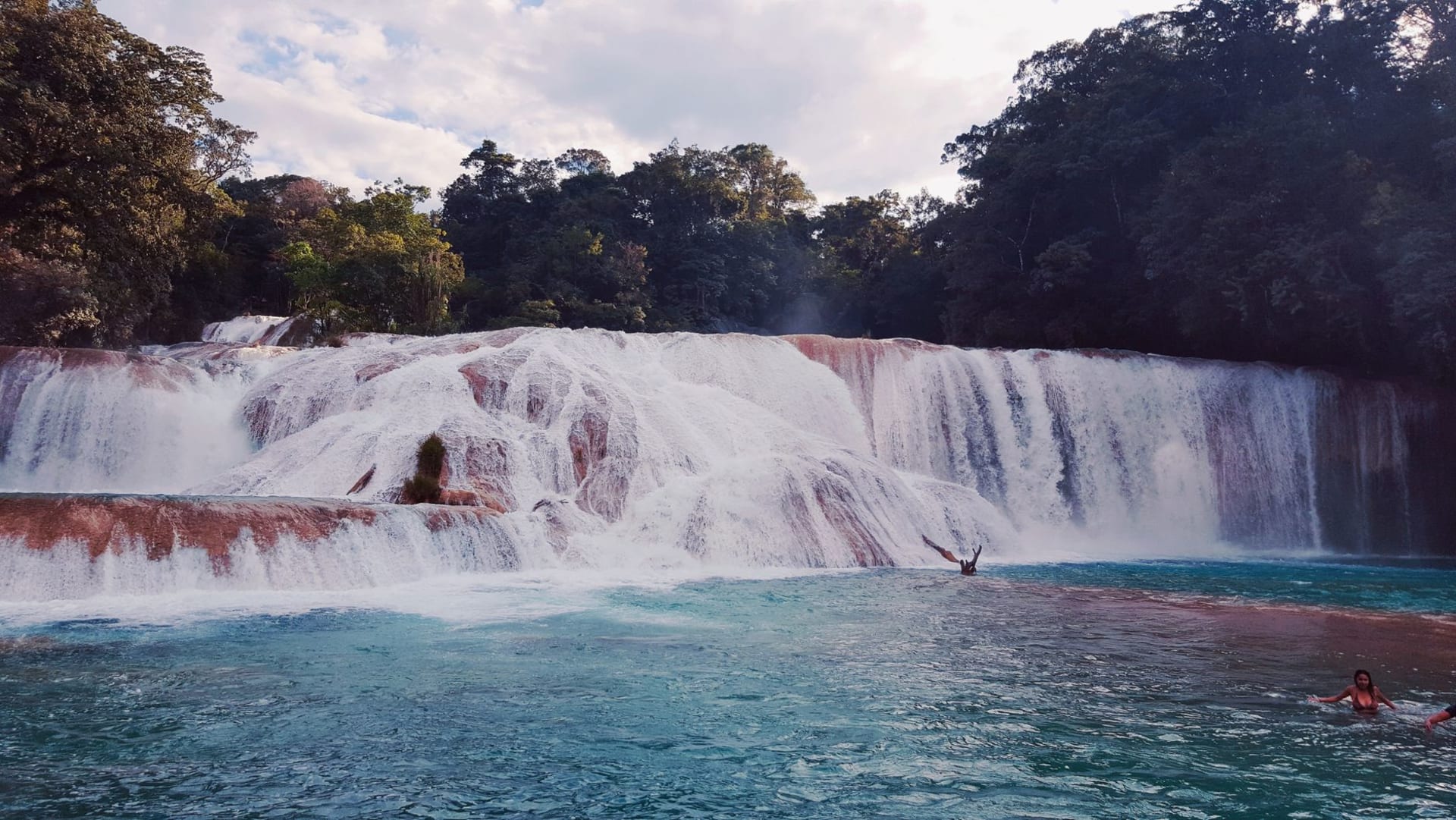 Tiered turquoise pools of Agua Azul waterfalls cascading through dense jungle in Chiapas, Mexico