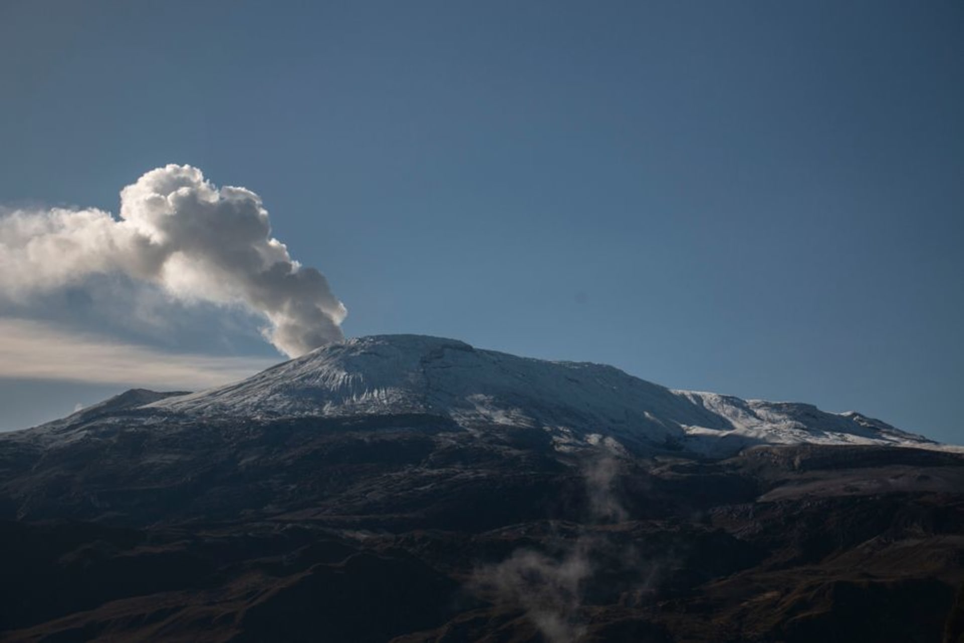 Snow-capped Nevado del Ruiz volcano rising above rolling páramo highlands