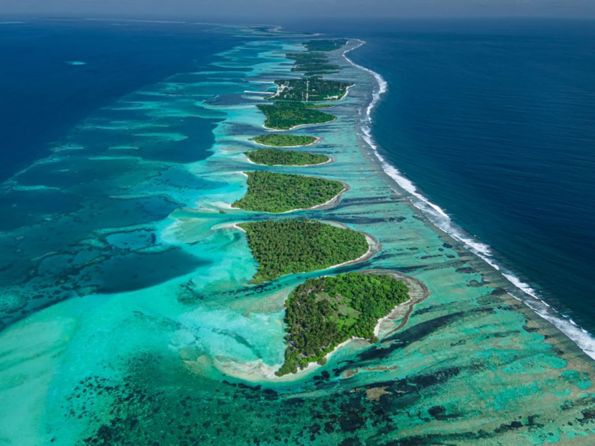 The turquoise lagoon and low coral motus of Palmerston Atoll seen from an approaching boat