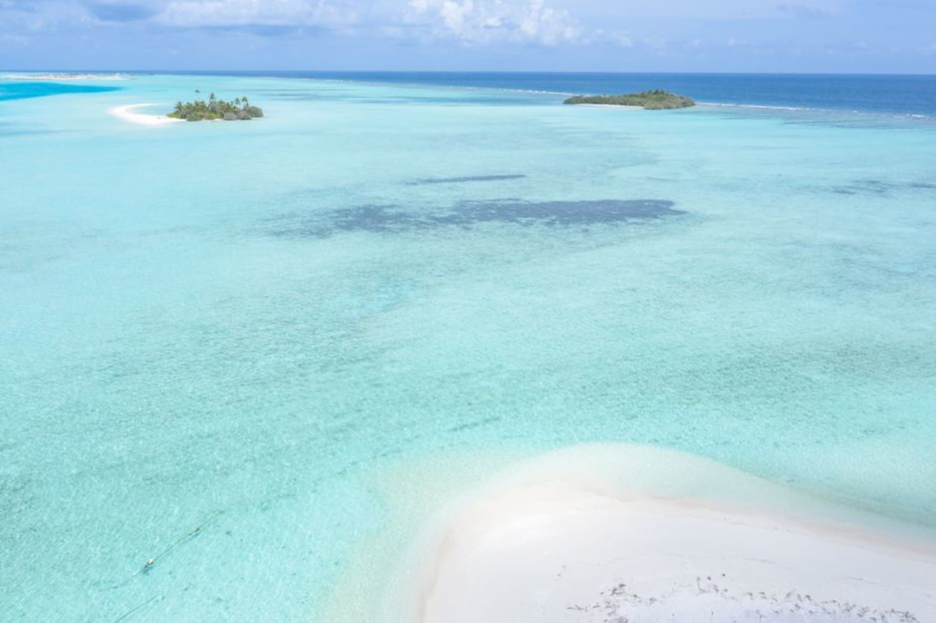 The triangular reef and three motus of Pukapuka atoll surrounded by open Pacific ocean
