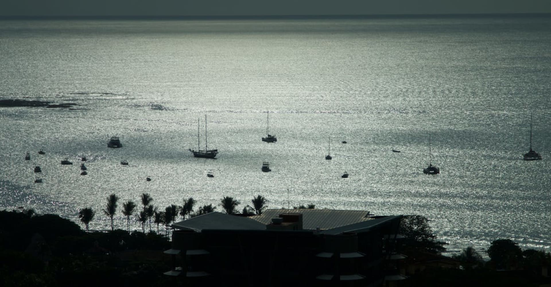Surfers in the water at Tamarindo beach during golden hour