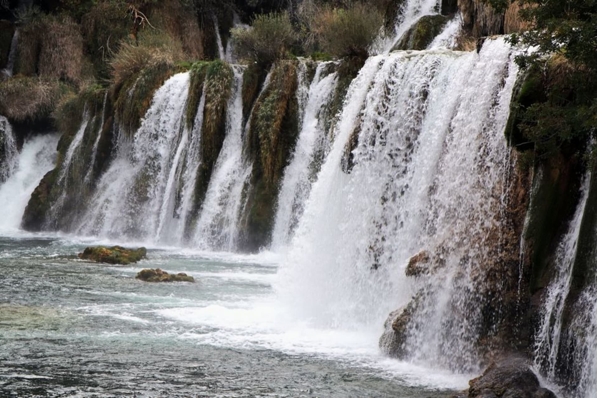 Cascadas escalonadas de travertino de Skradinski buk cayendo entre el bosque verde en el Parque Nacional de Krka