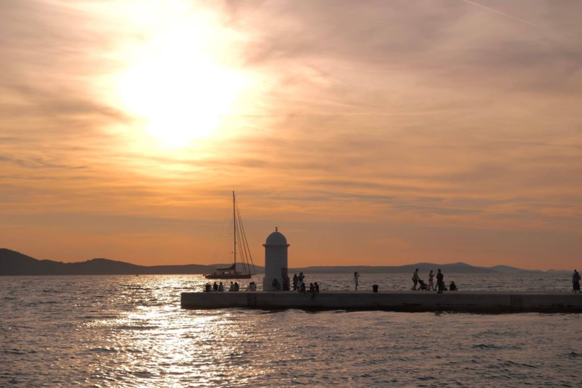 The waterfront promenade of Zadar at sunset with the Sea Organ steps meeting the Adriatic