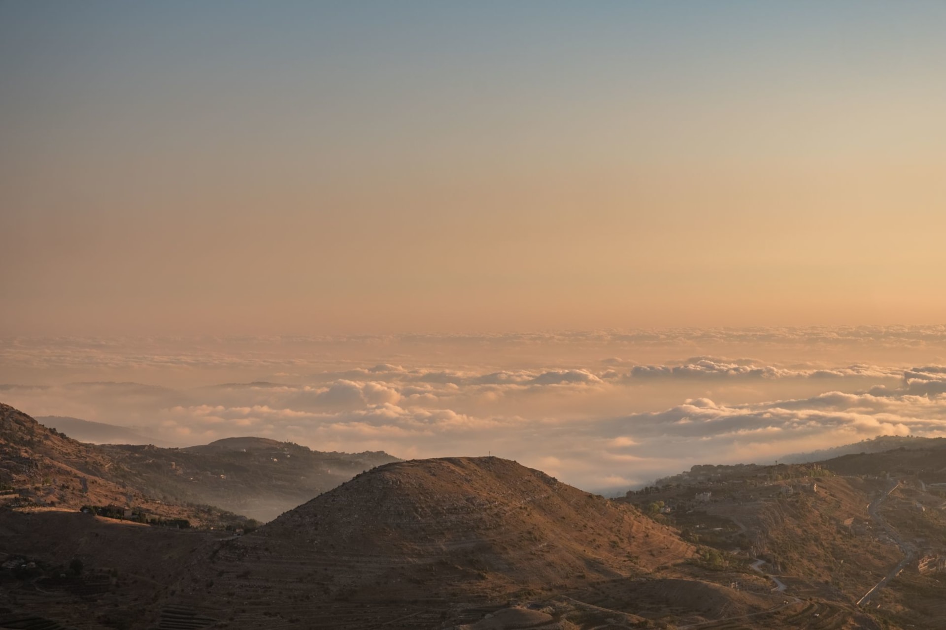 The bronze serpent sculpture on Mount Nebo against a wide panoramic view of the Jordan Valley, Dead Sea, and distant hills of the West Bank