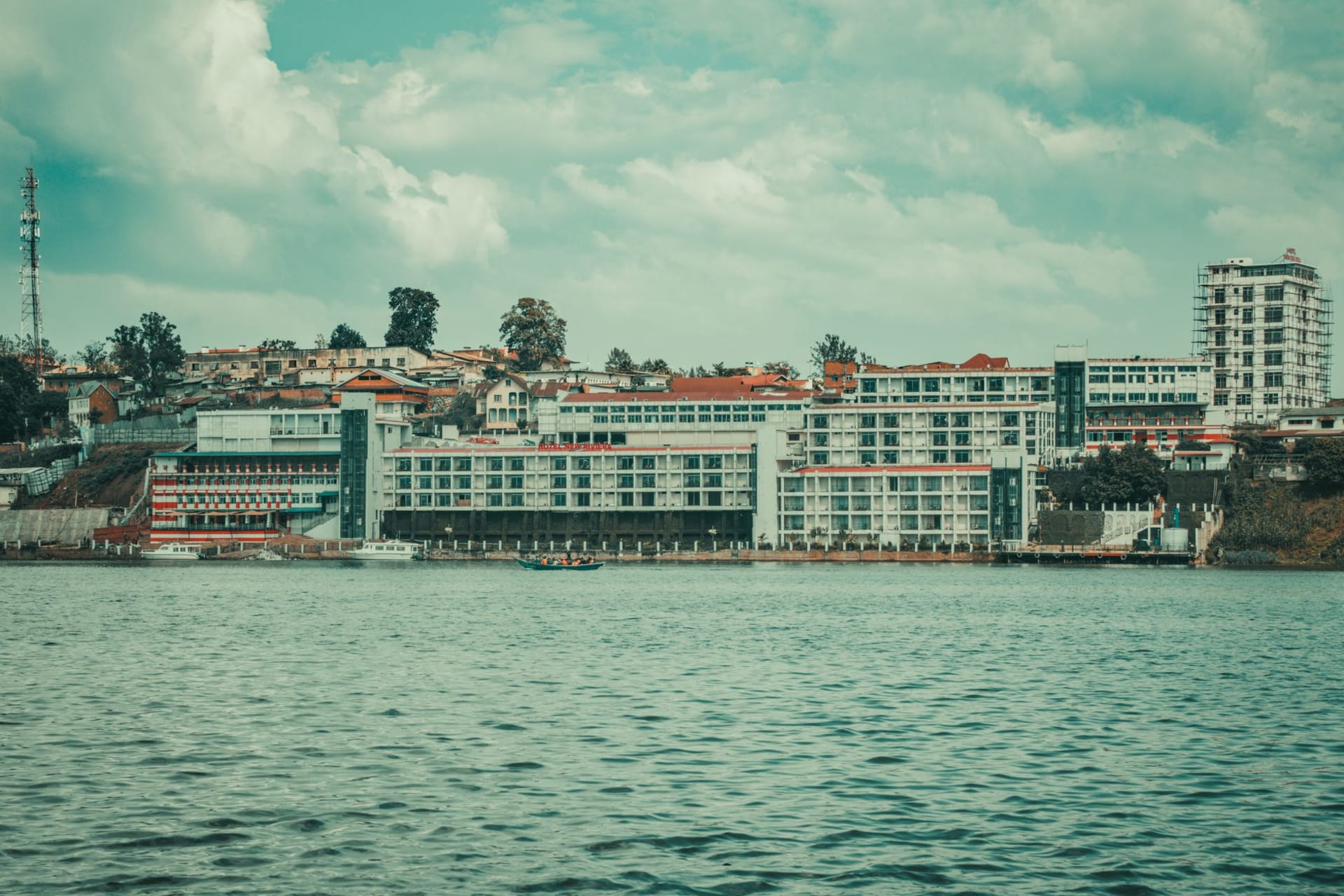 Bukavu's five green peninsulas jutting into Lake Kivu at late afternoon, colonial-era rooftops visible through the trees, water reflecting the hills