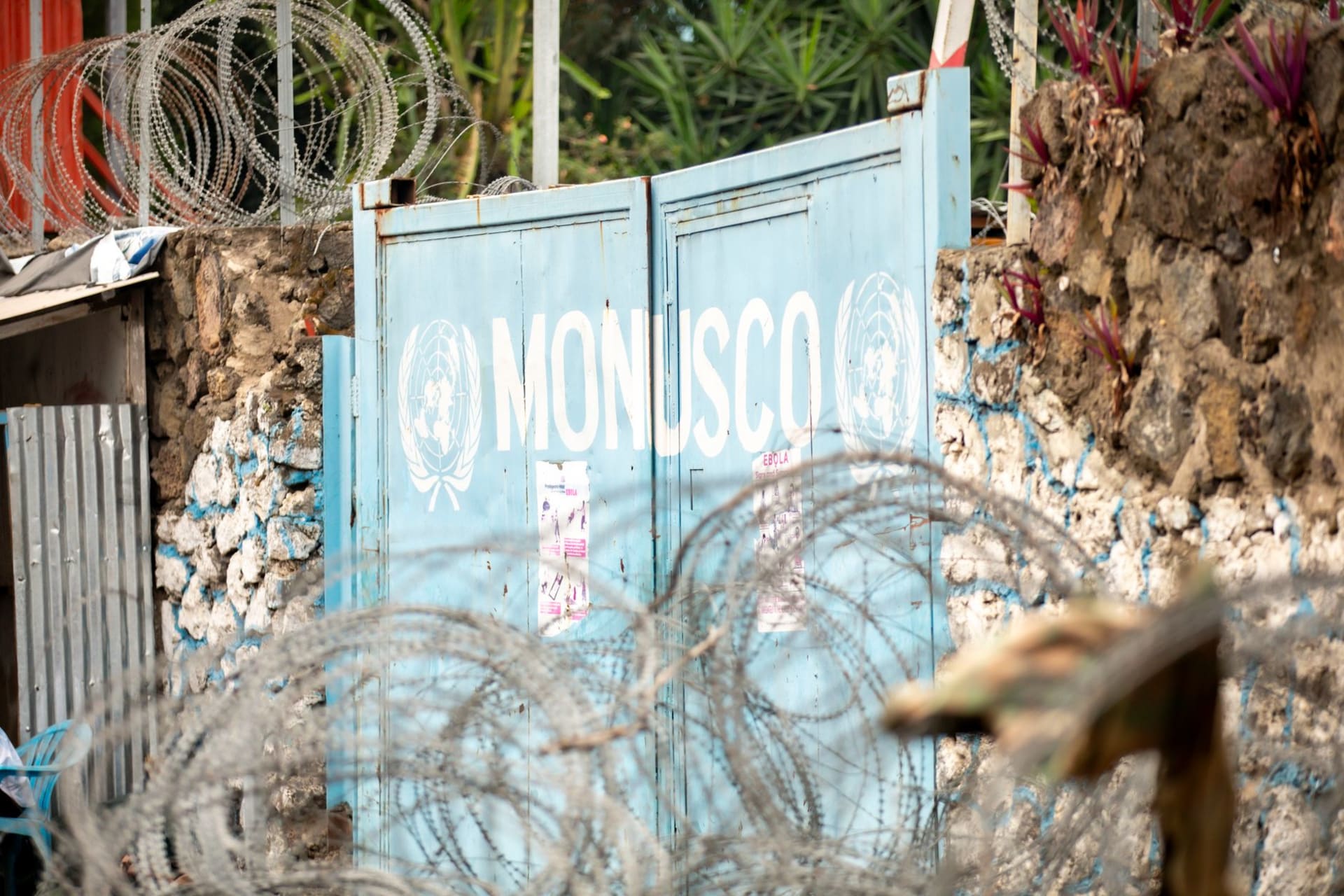 Las calles comerciales de Goma construidas sobre roca volcánica oscura con el agua azul del lago Kivu y las colinas verdes al fondo