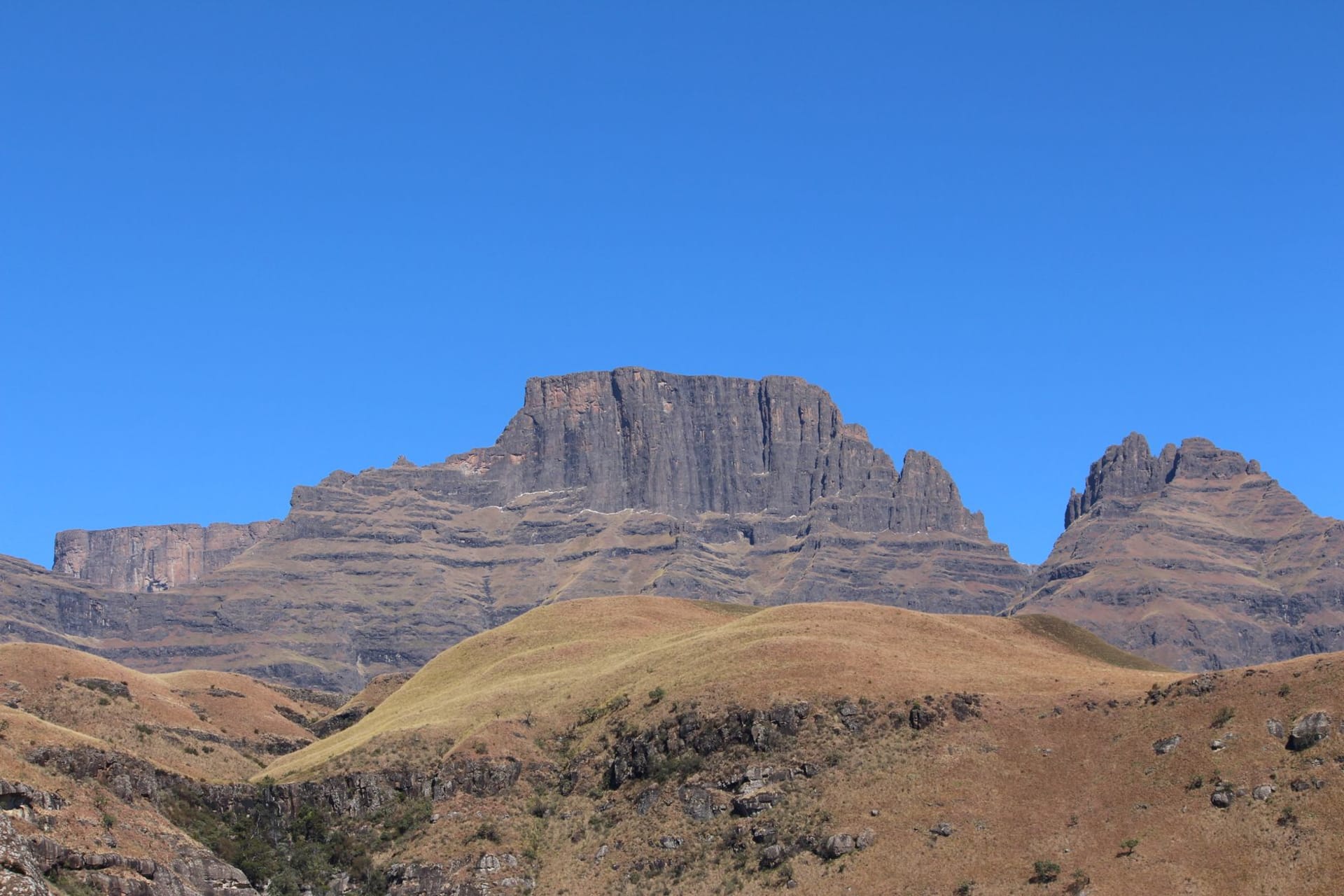 Cathedral Peak's distinctive rock spire rising above green foothills in soft morning light