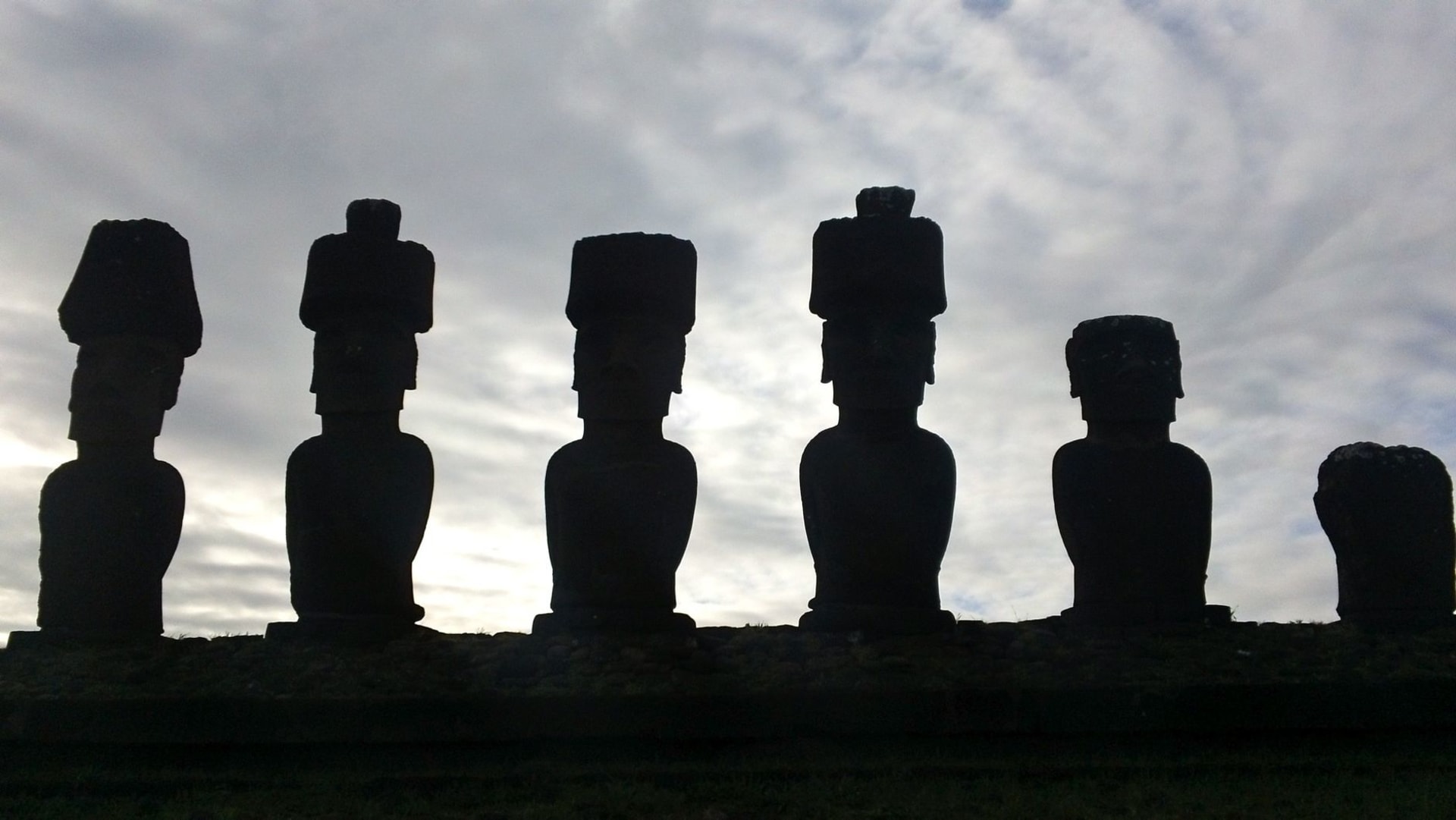 The massive fallen moai Paro at Te Pito Kura lying face-down near the ocean, with the sacred spherical stone in the foreground