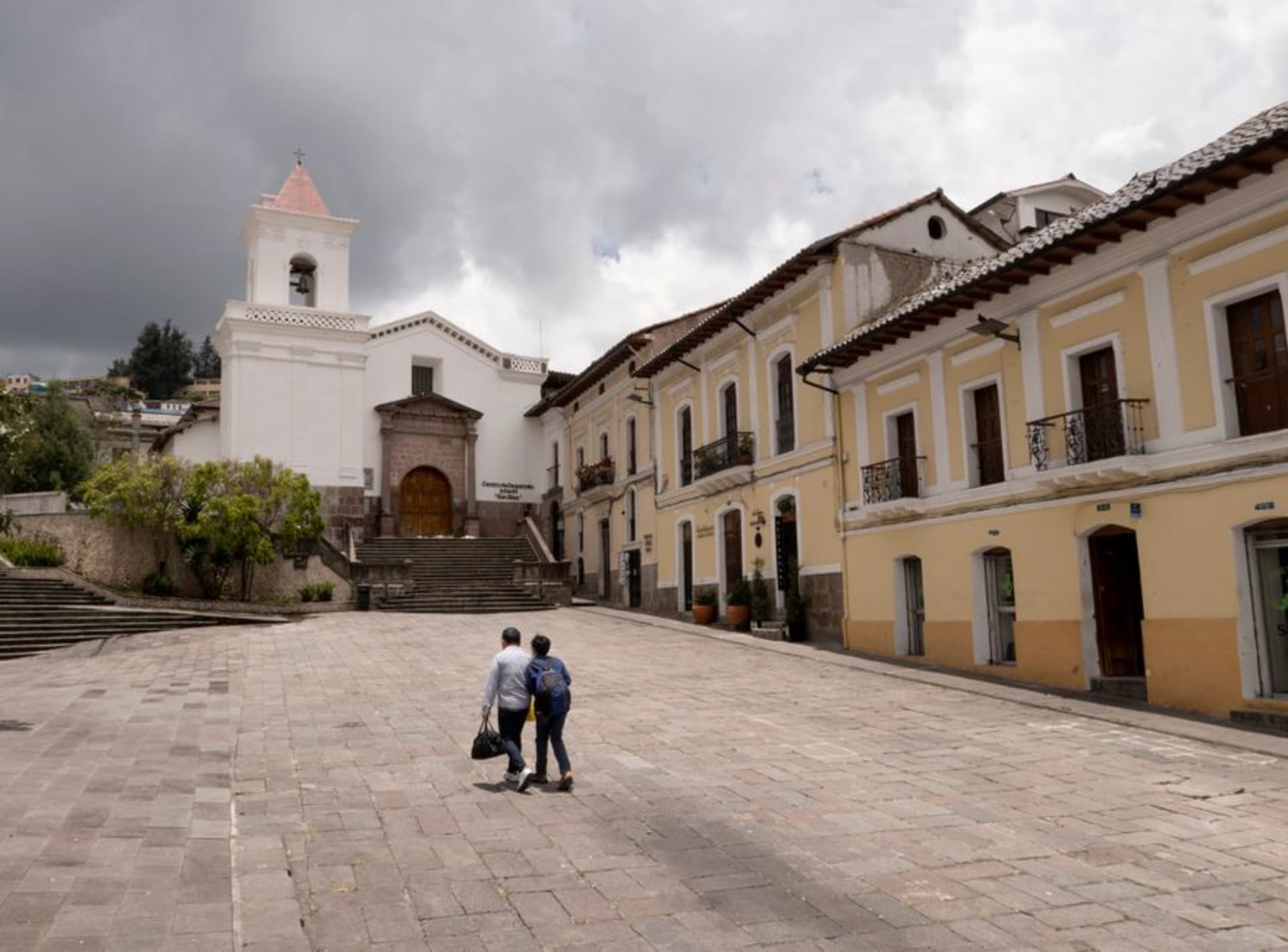 The colonial center of Loja, Ecuador, with pastel-painted buildings and a church tower under an Andean sky