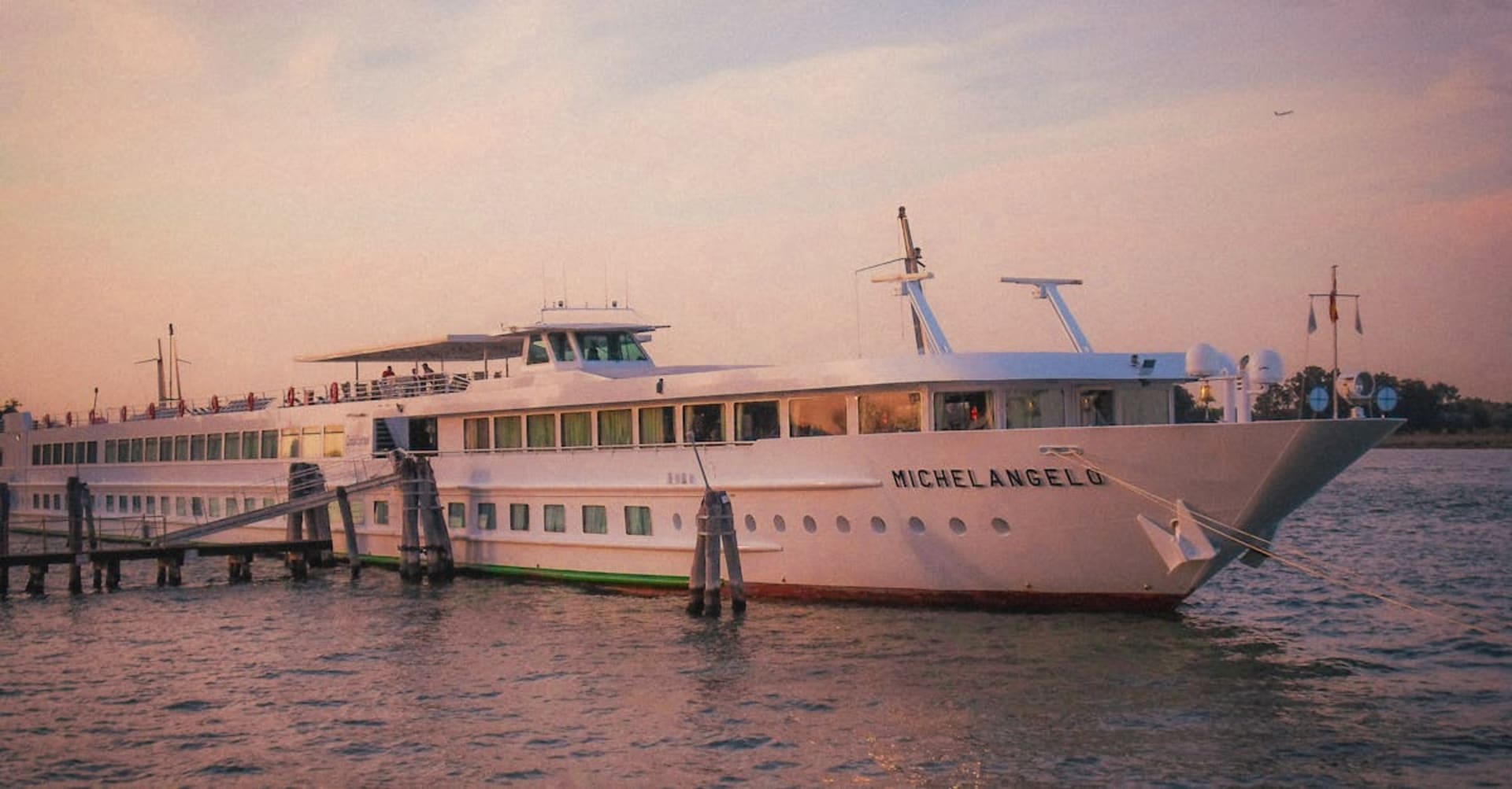 Traditional wooden dahabiya sailing boat on the Nile with palm-lined banks