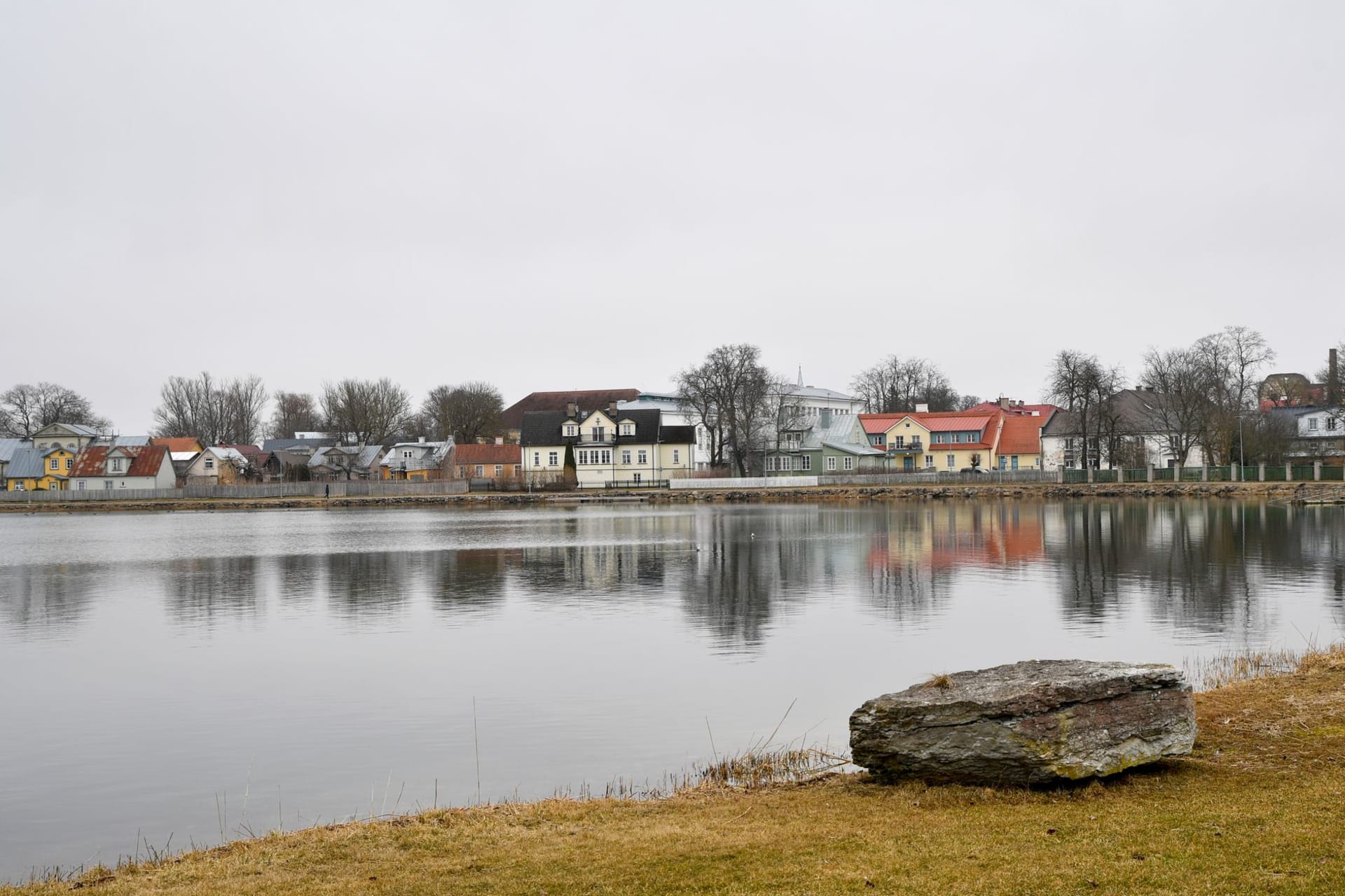 The ruined medieval walls of Haapsalu Bishop's Castle reflected in still water at golden hour